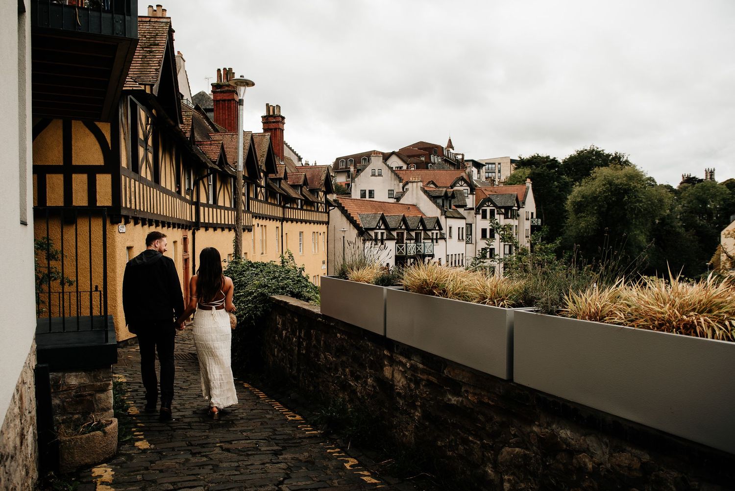 Panoramic view of historic stone buildings and garden paths in Edinburgh's Dean Village.