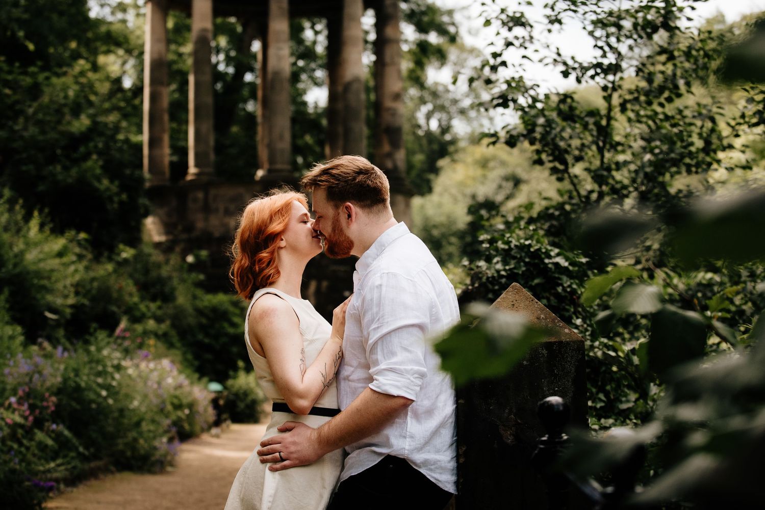 Romantic moment captured in a lush green garden setting during summer.
