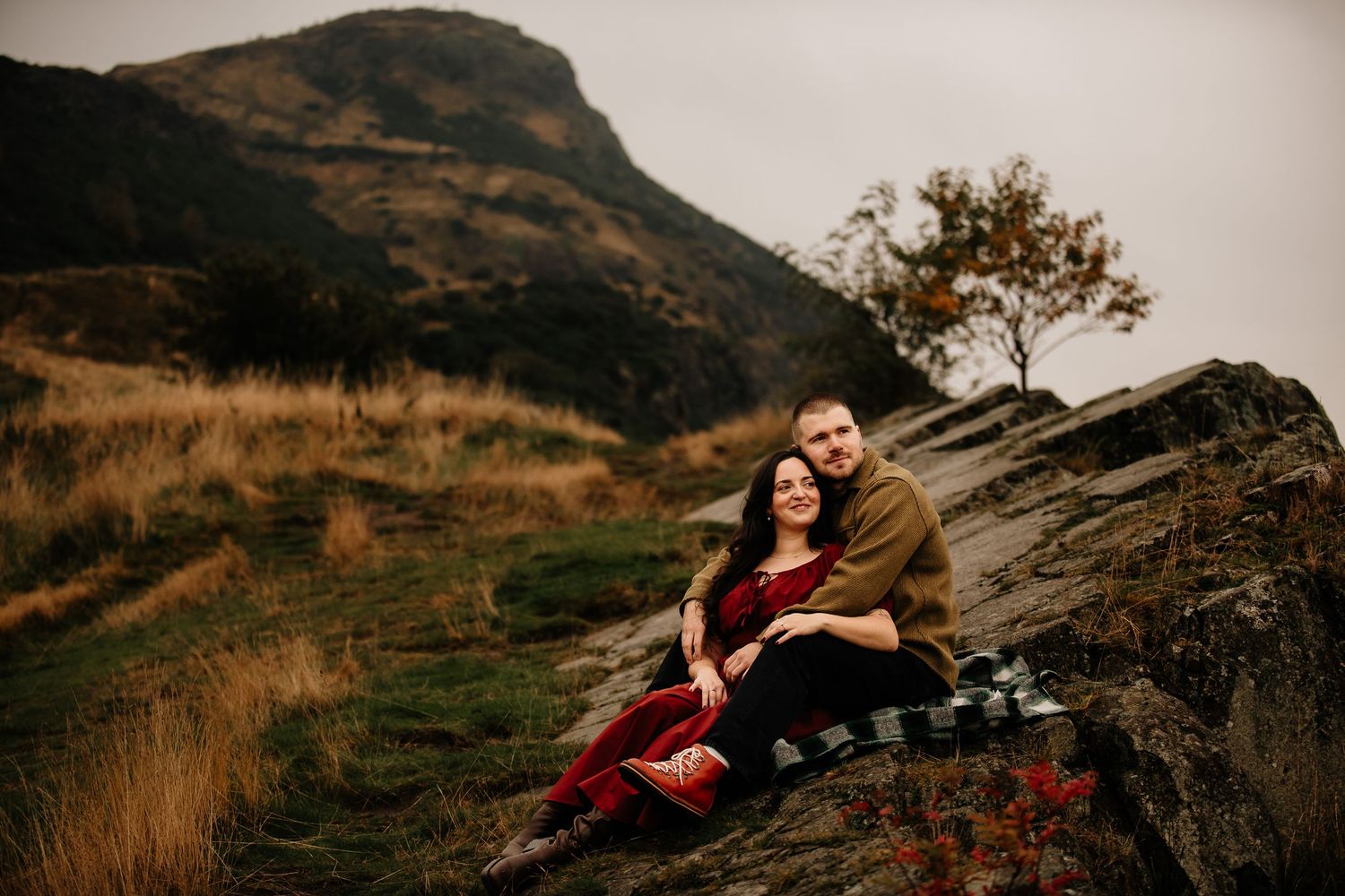 Dramatic mountainous landscape serves as backdrop for romantic outdoor photoshoot.