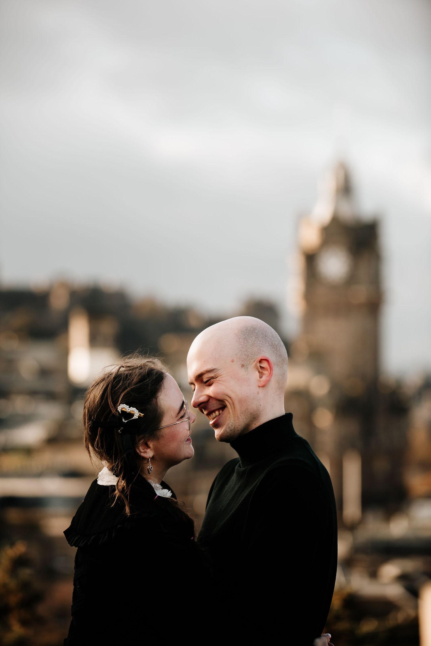 Romantic moment captured against Edinburgh's historic skyline.