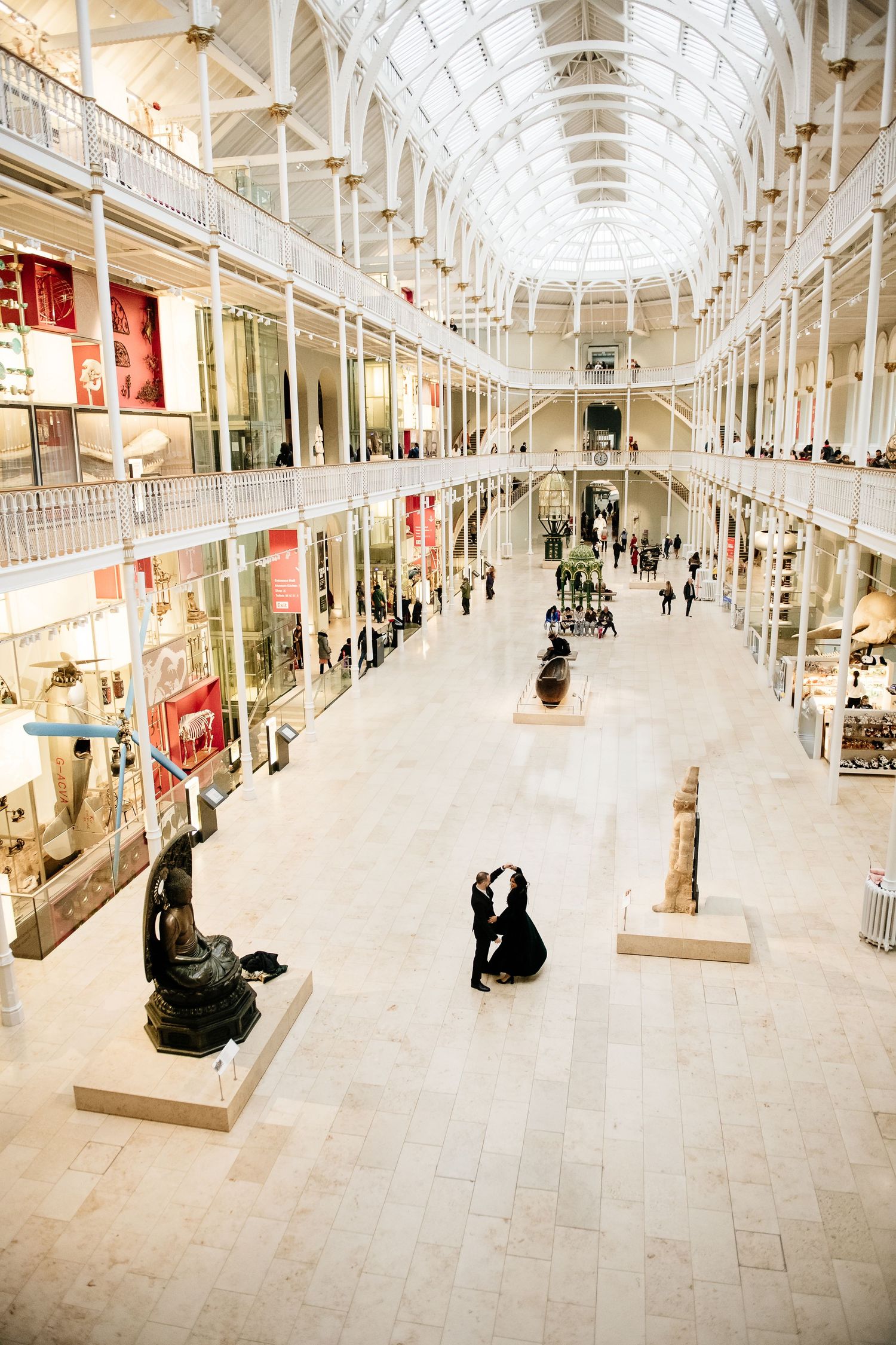 Panoramic view of Scotland's National Museum with white vaulted ceilings, stone floors and retail storefronts.