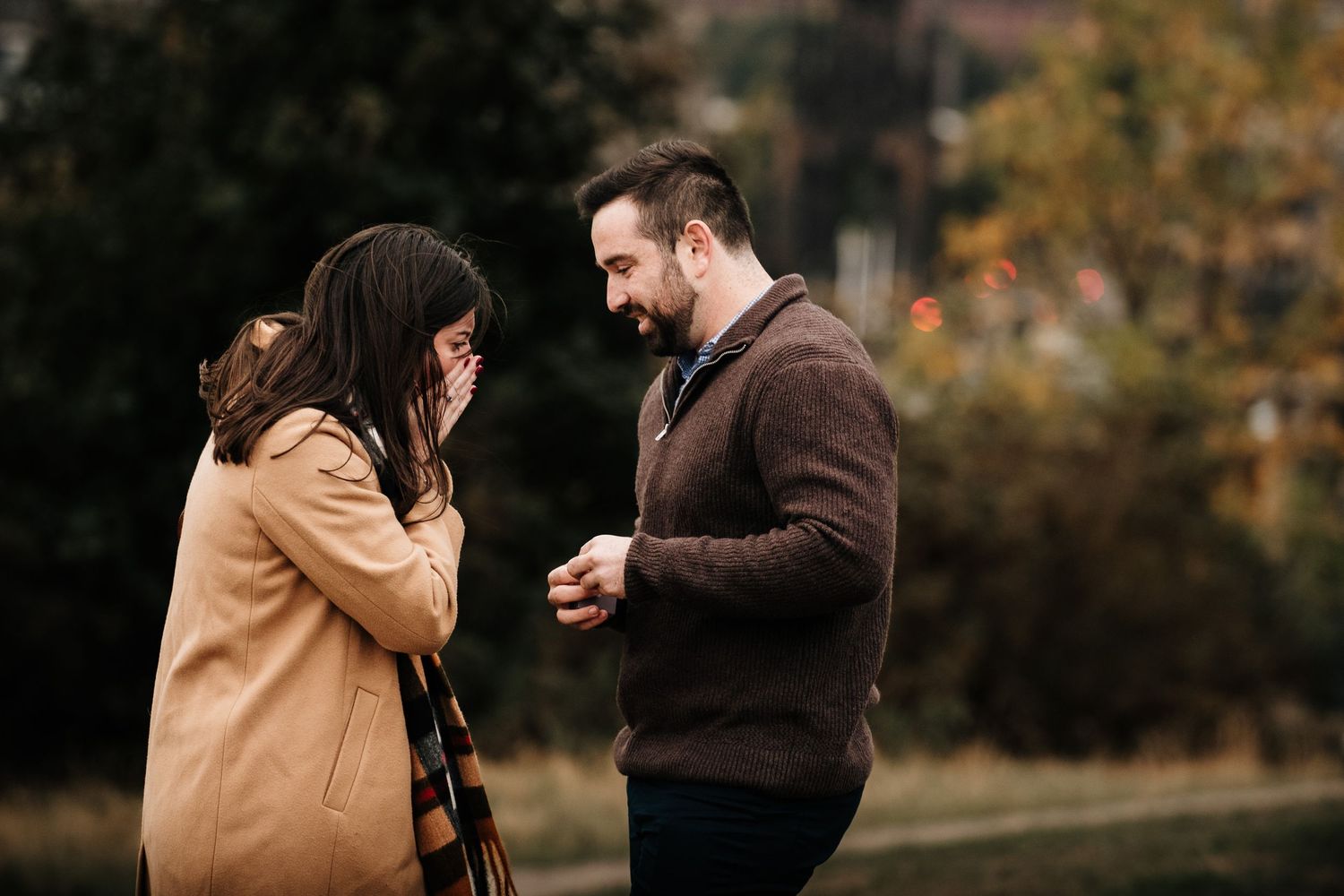 Couple sharing an emotional moment in a park during autumn.