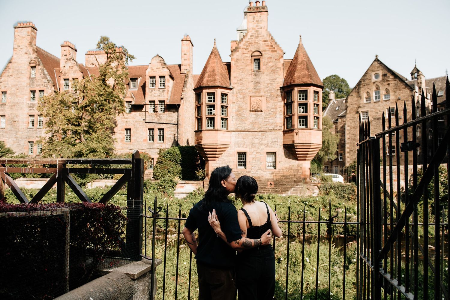 Beautiful Scottish architecture with red stone buildings and iron fencing in warm sunlight.