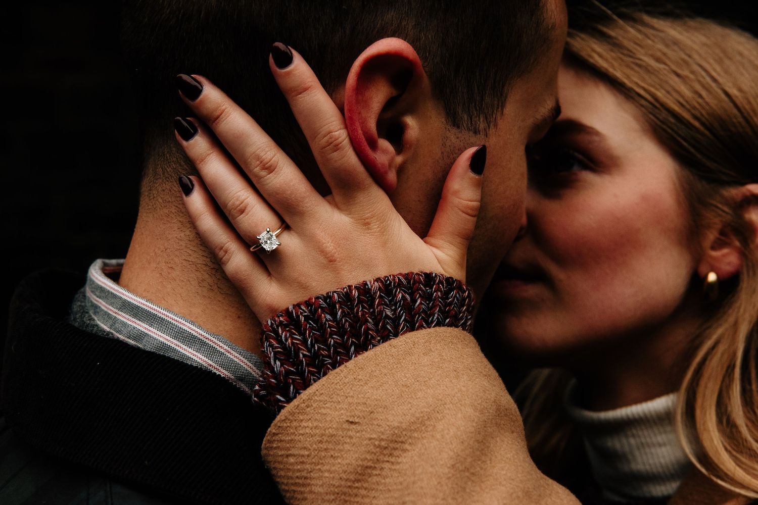 Close-up shot of an engagement ring with an intimate embrace.