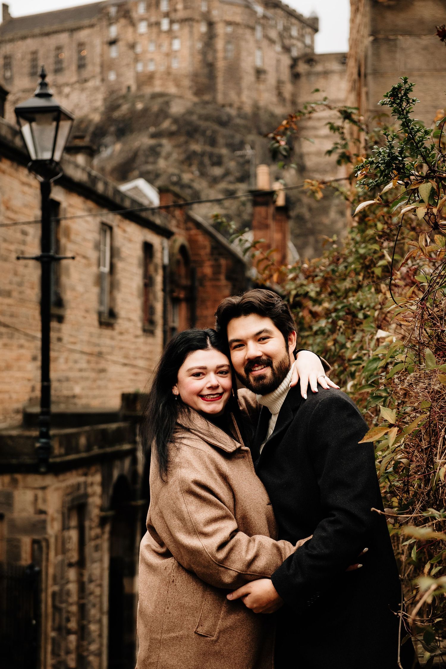 Cozy couple portrait against the dramatic backdrop of Edinburgh Castle.