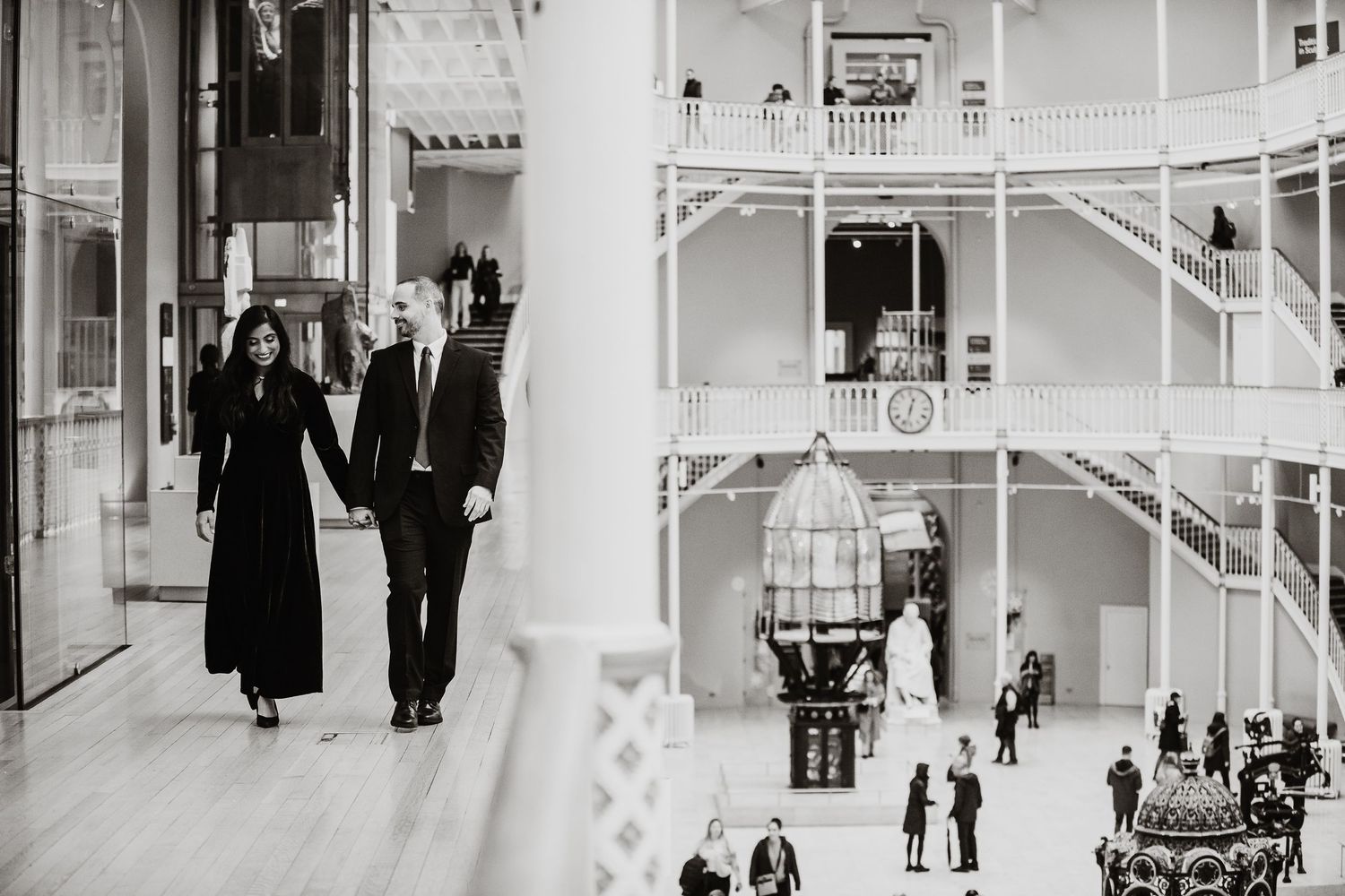 A black and white photo montage showing multiple scenes of people walking through the interior Scotland's National Museum.