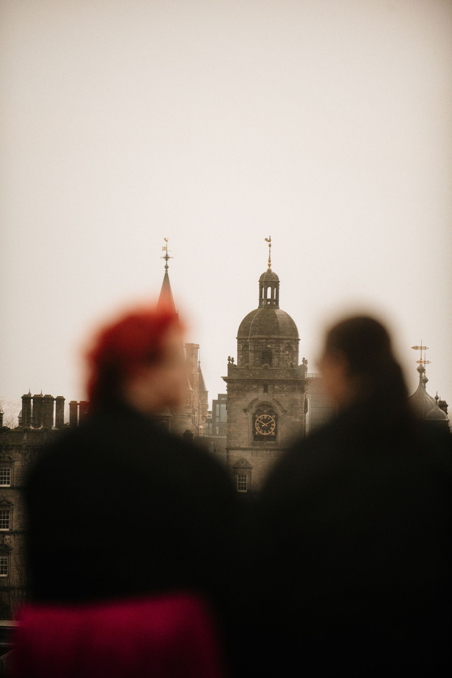 Silhouetted church spires and buildings against a moody sky create a dramatic cityscape at dusk.