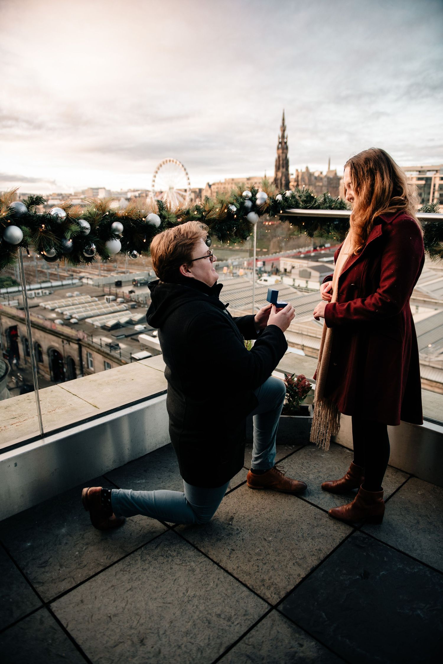 A series of proposal photos on a rooftop overlooking Edinburgh's historic cityscape at sunset.