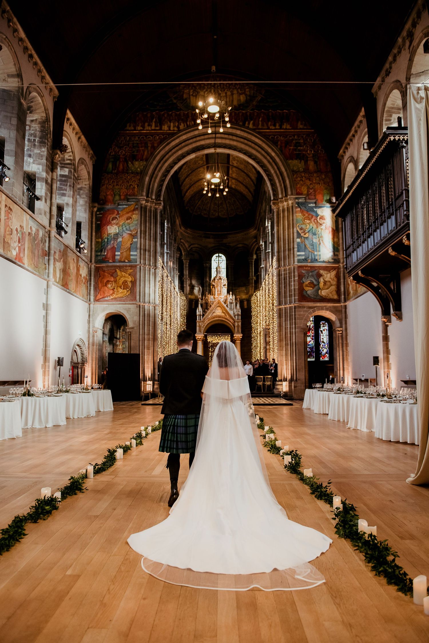 Wedding dress with flowing train photographed in a grand cathedral with ornate architecture.