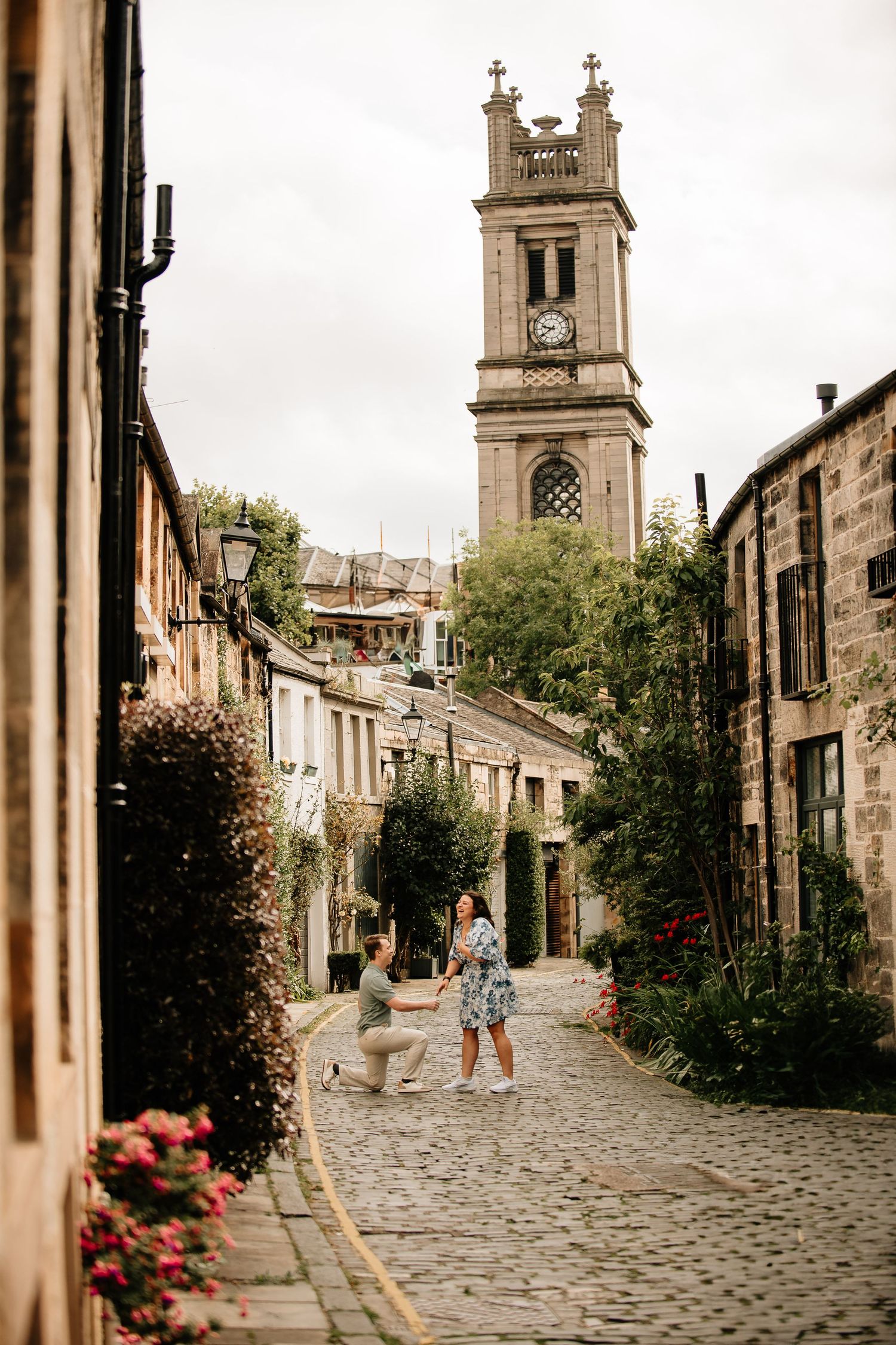 Cobblestone street in Edinburgh's historic district with church spires and stone buildings.