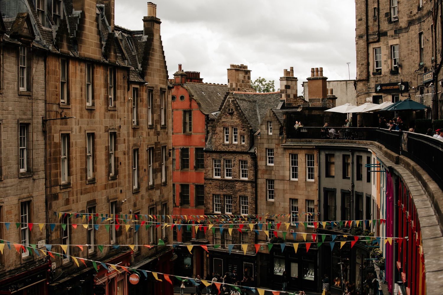 Historic stone buildings and architecture along Victoria Street in Edinburgh's Old Town on an overcast day.