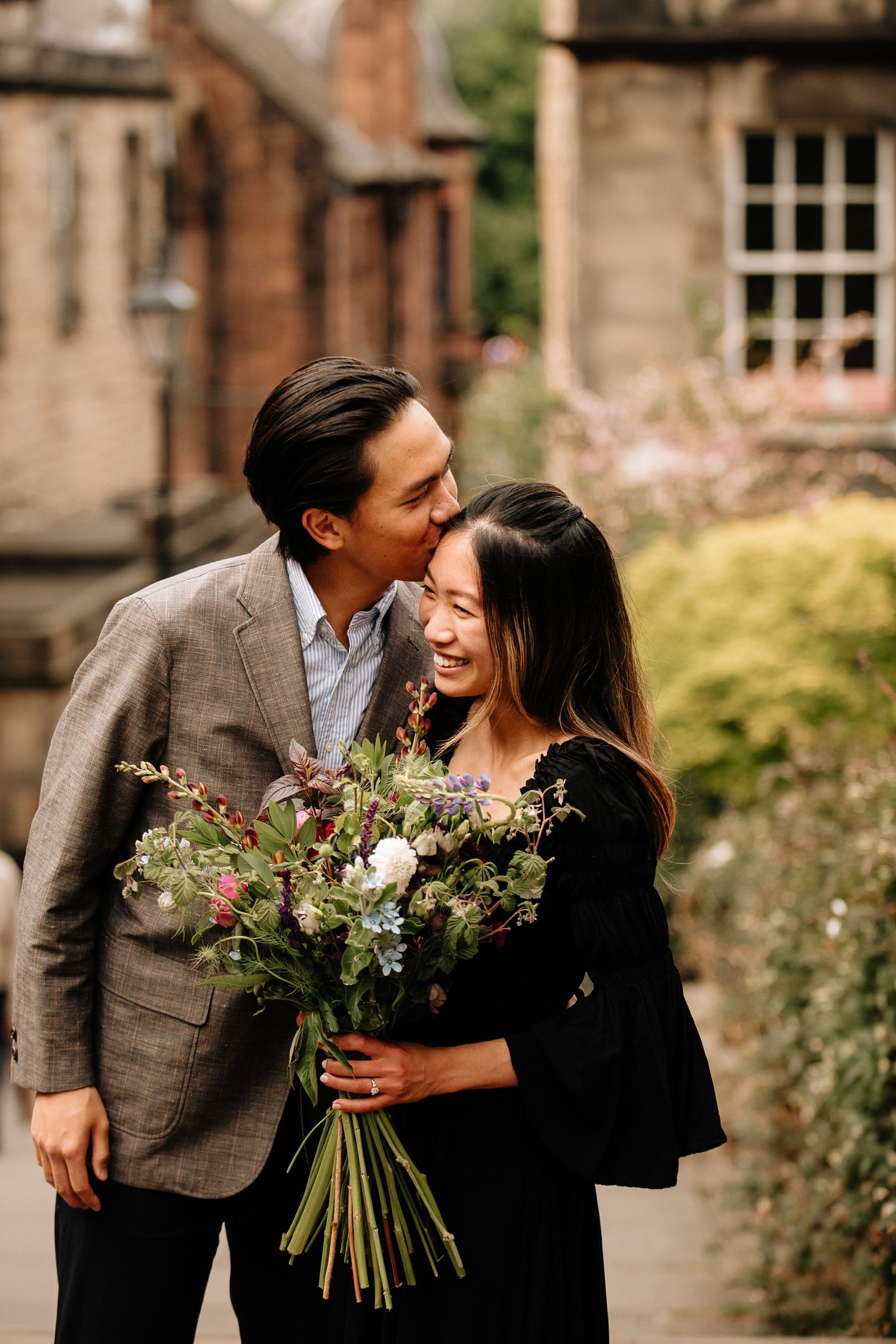 A couple shares a tender moment with a beautiful bouquet of flowers in an Edinburgh courtyard.