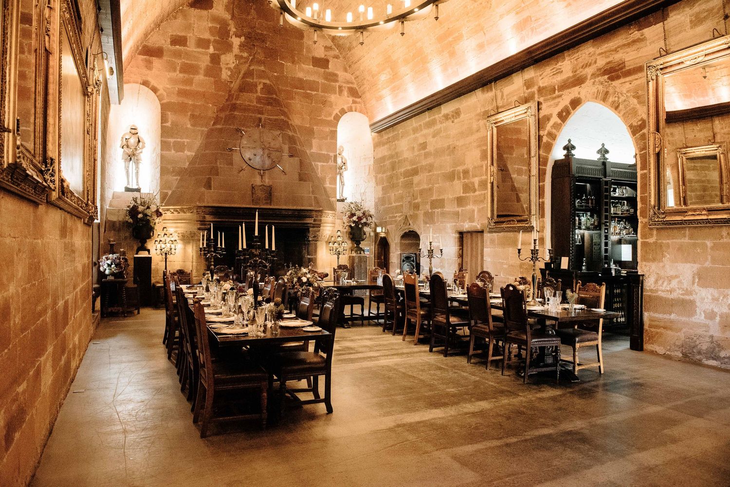 Elegant stone castle reception venue with vaulted ceilings and ambient lighting.