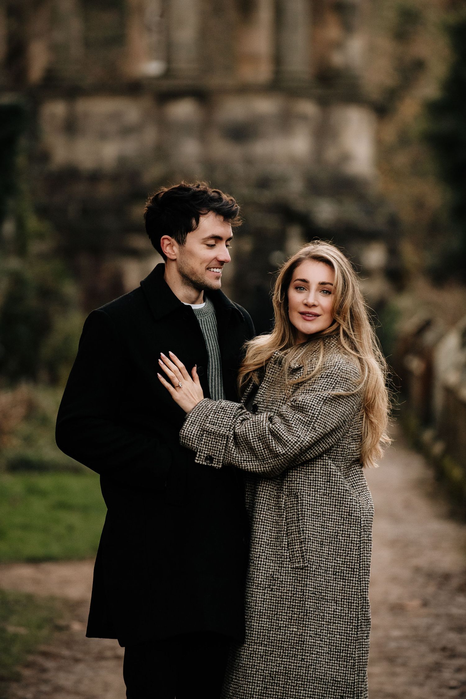 Couple sharing intimate moments in a cozy outdoor setting wearing casual autumn attire.