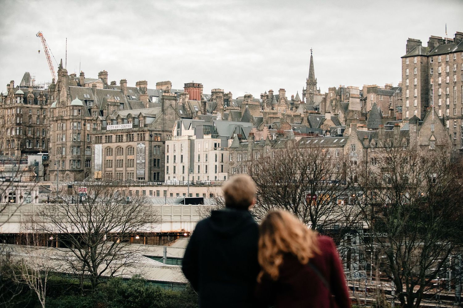 Panoramic cityscape view of Edinburgh's historic Old Town with church spires and traditional stone buildings.