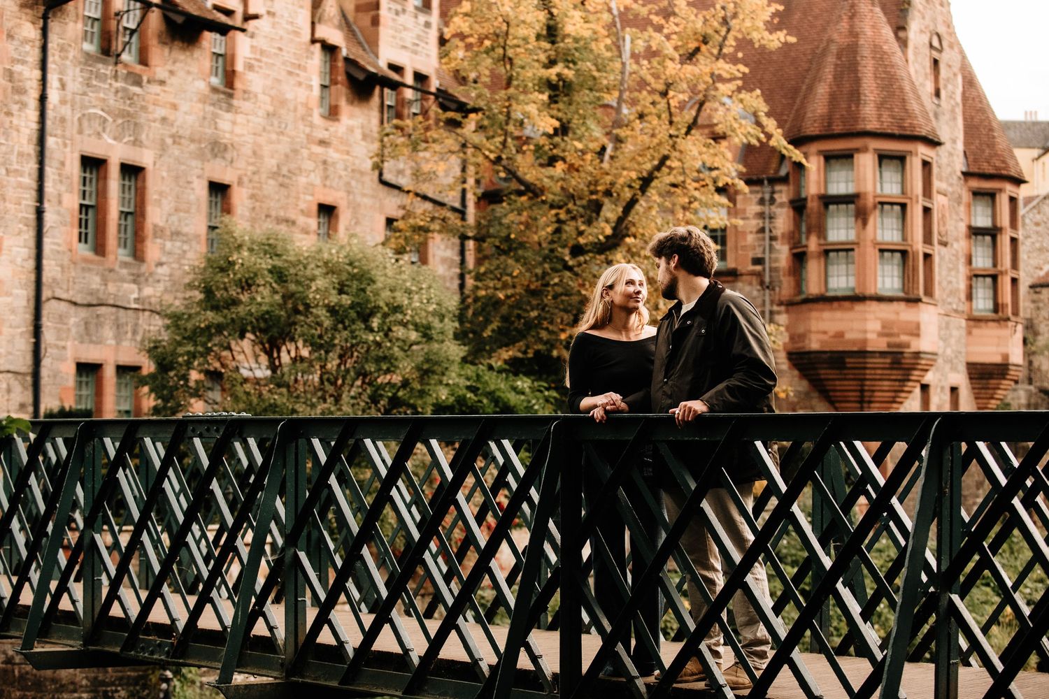 Wide view of iron bridge railing with historic stone buildings in Dean Village Edinburgh.