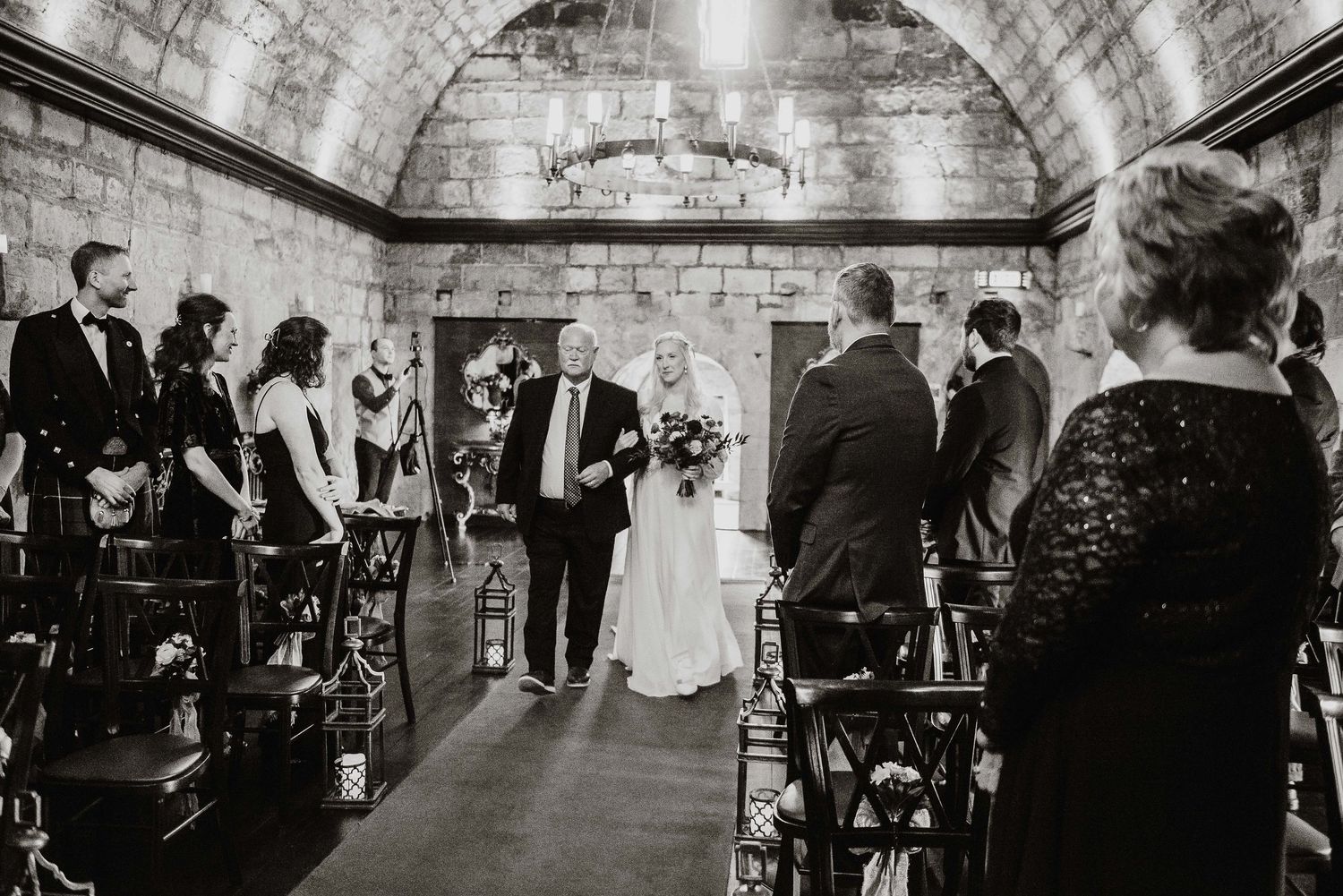 Historic stone venue interior with arched ceilings set for wedding reception.