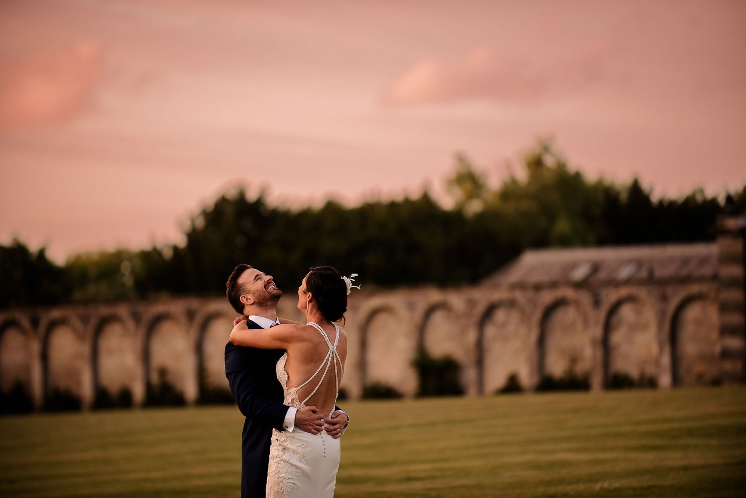 A sunset dance against a backdrop of historic stone arches and manicured lawn.
