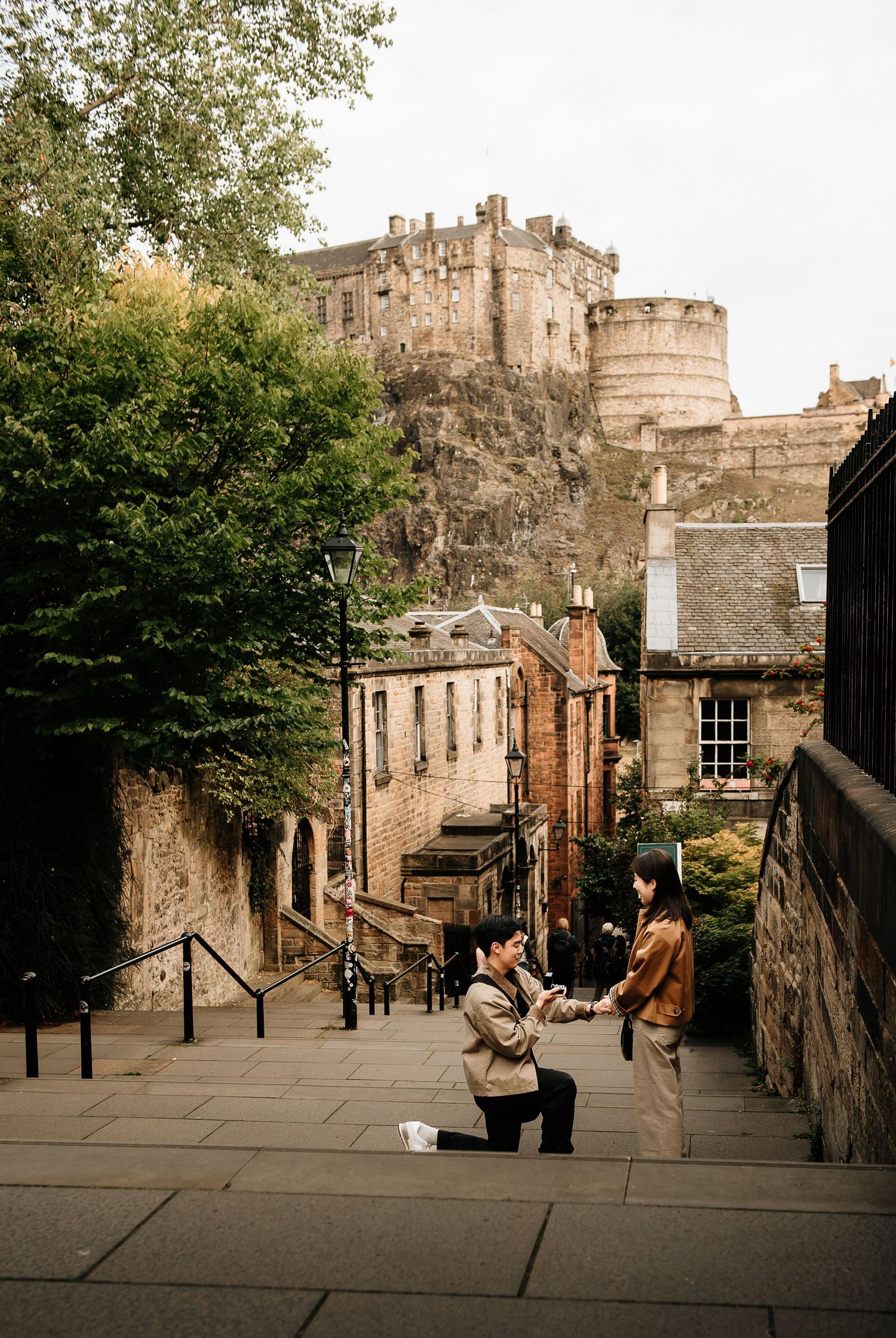 Cobblestone street leading to Edinburgh Castle with historic buildings lining the path.