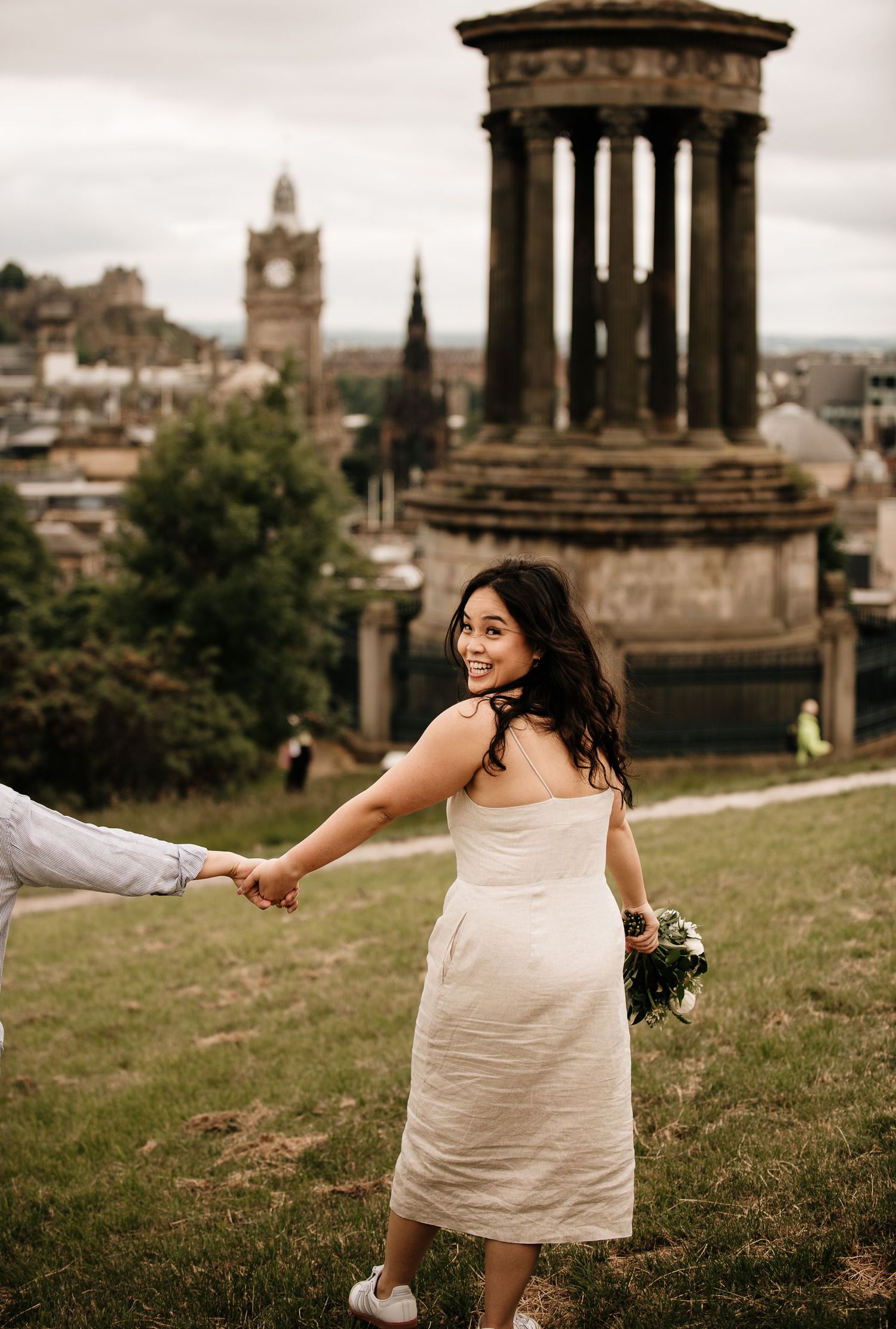 Romantic moment at Calton Hill with Edinburgh's historic monument and cityscape backdrop.