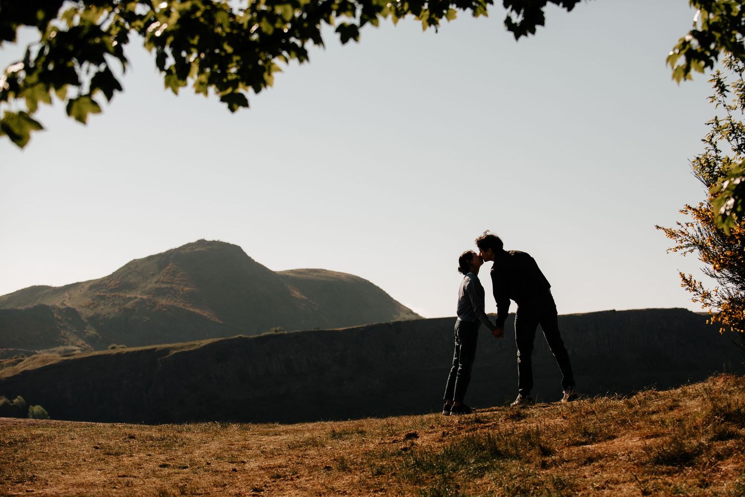 Silhouettes against a mountain backdrop during golden hour.