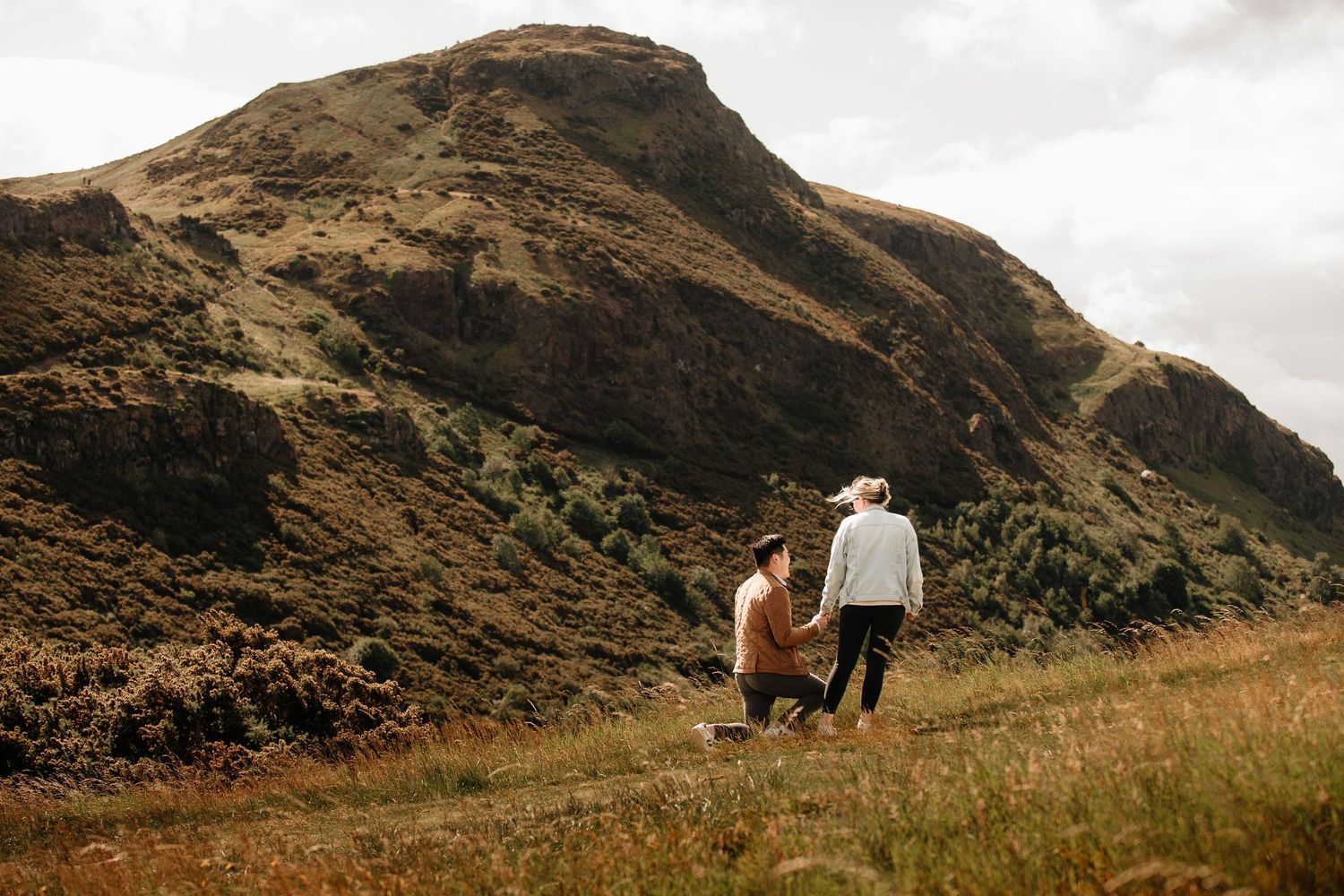 A scenic mountain landscape with rolling hills and dramatic clouds.
