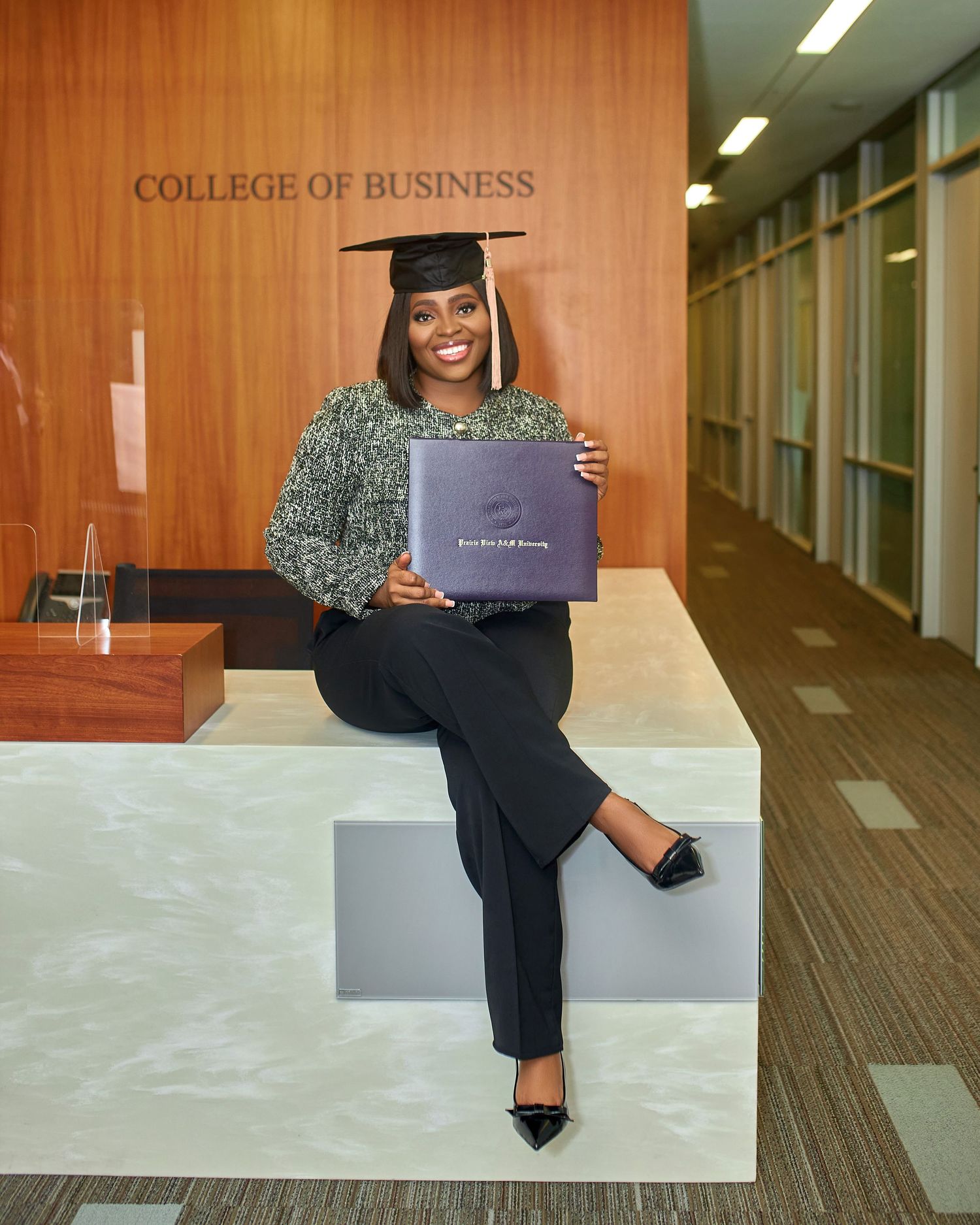 Professional graduation photos taken in modern college business building hallway.