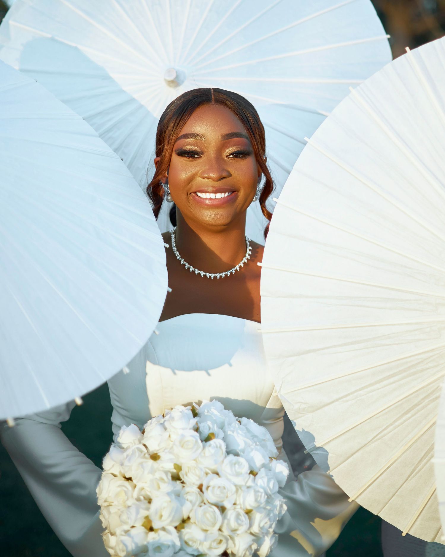 Elegant wedding photos with white parasols and bouquet of roses.