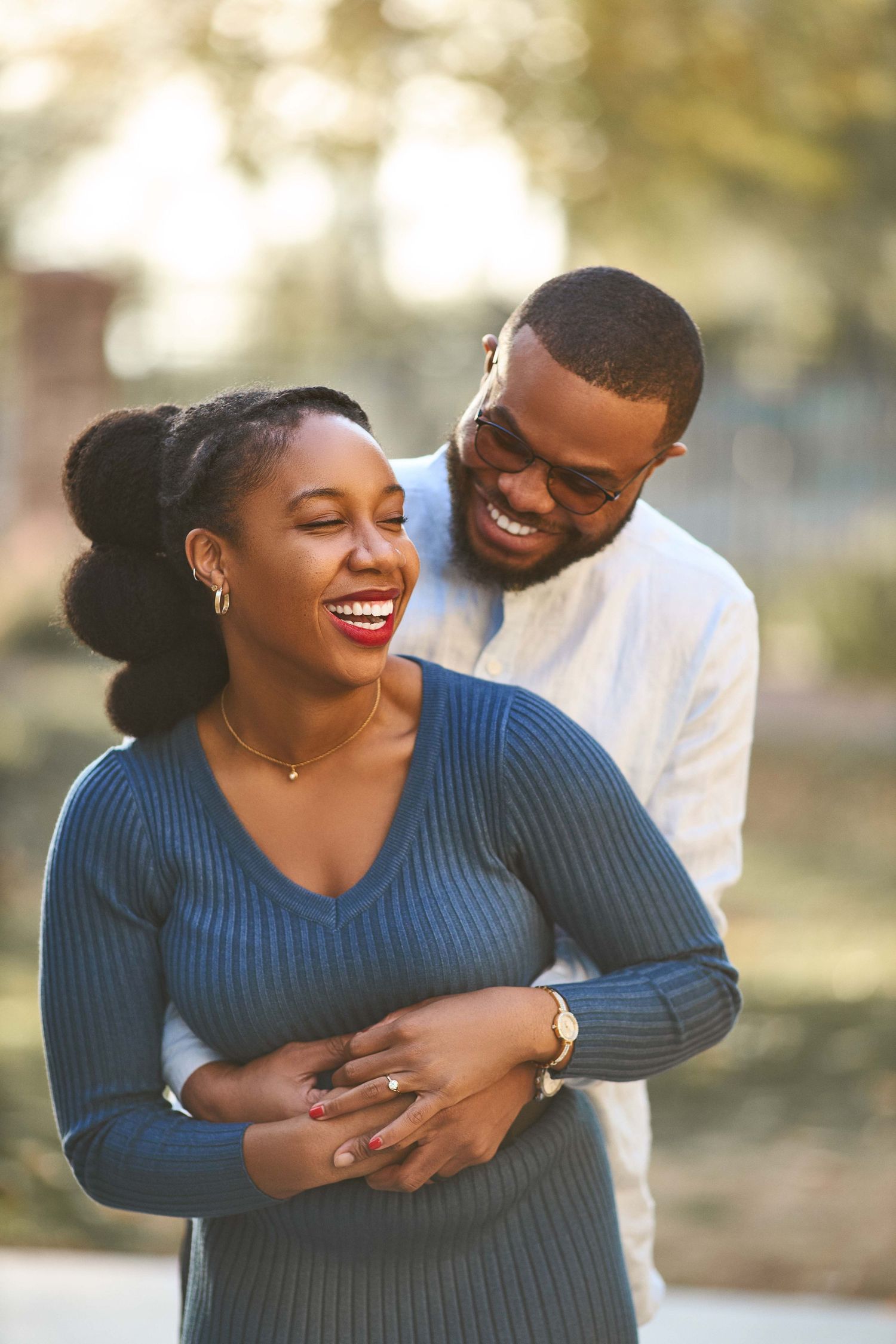 Couple shares loving embrace while wearing blue and white casual outfits.