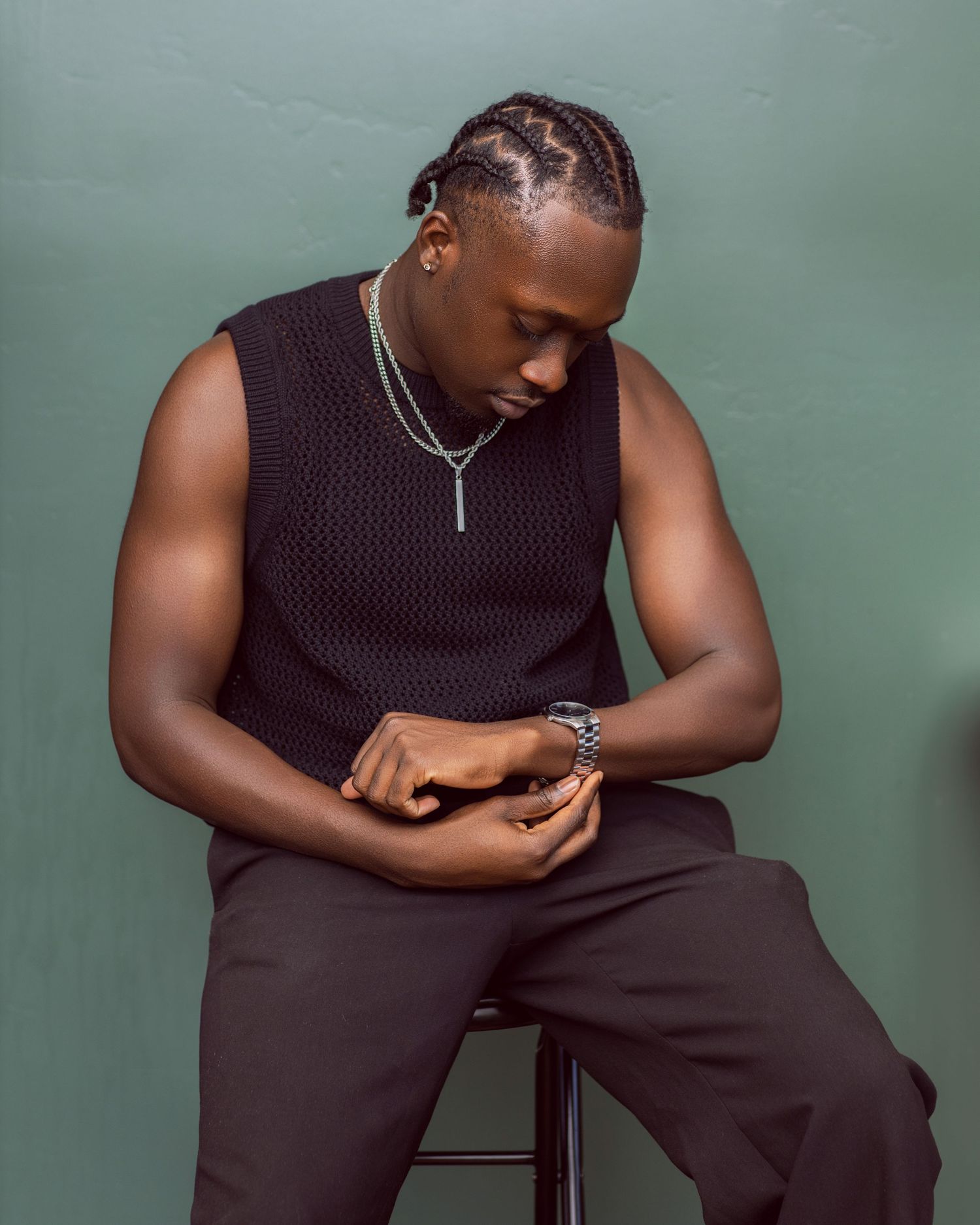 Artistic portrait series in black attire against a green background showing contemplative poses.