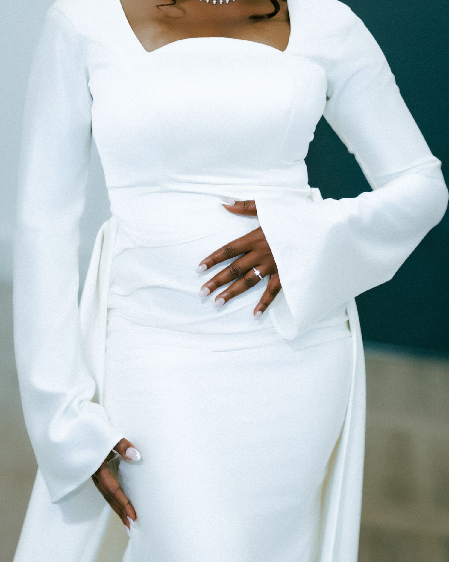 Elegant white gown with dramatic bell sleeves and fitted silhouette shown from multiple angles against dark background.