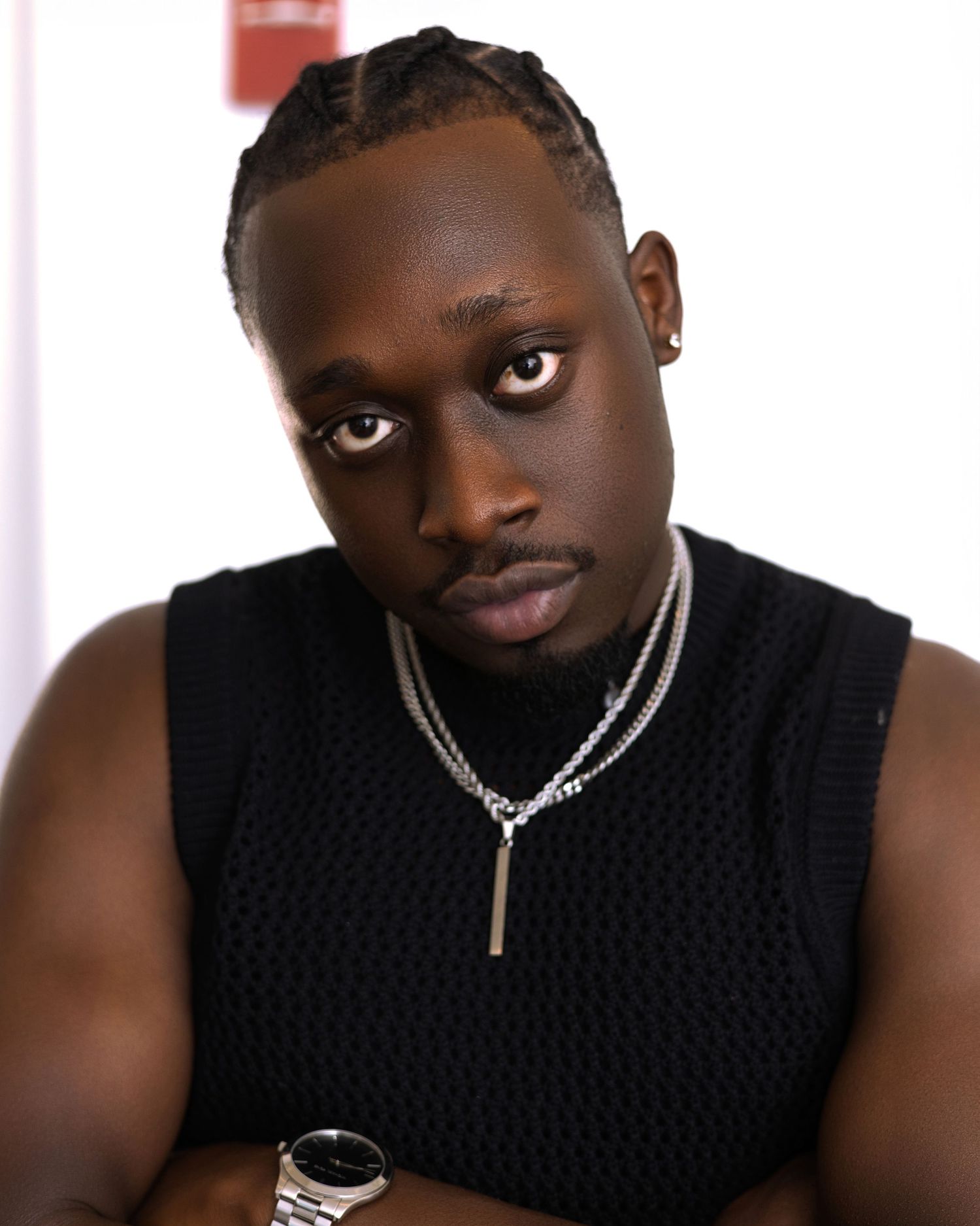 Portrait series showing different expressions while wearing a black sleeveless top and silver necklace.