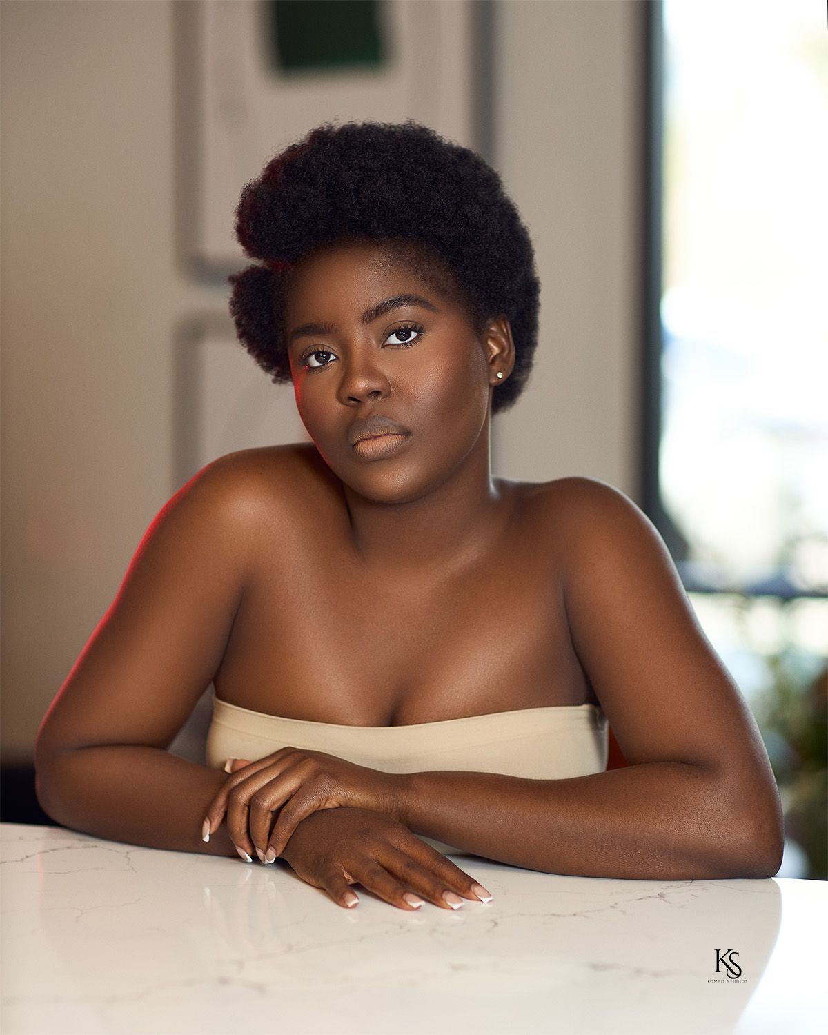 Minimalist portrait series with nude shoulders against white marble counter.
