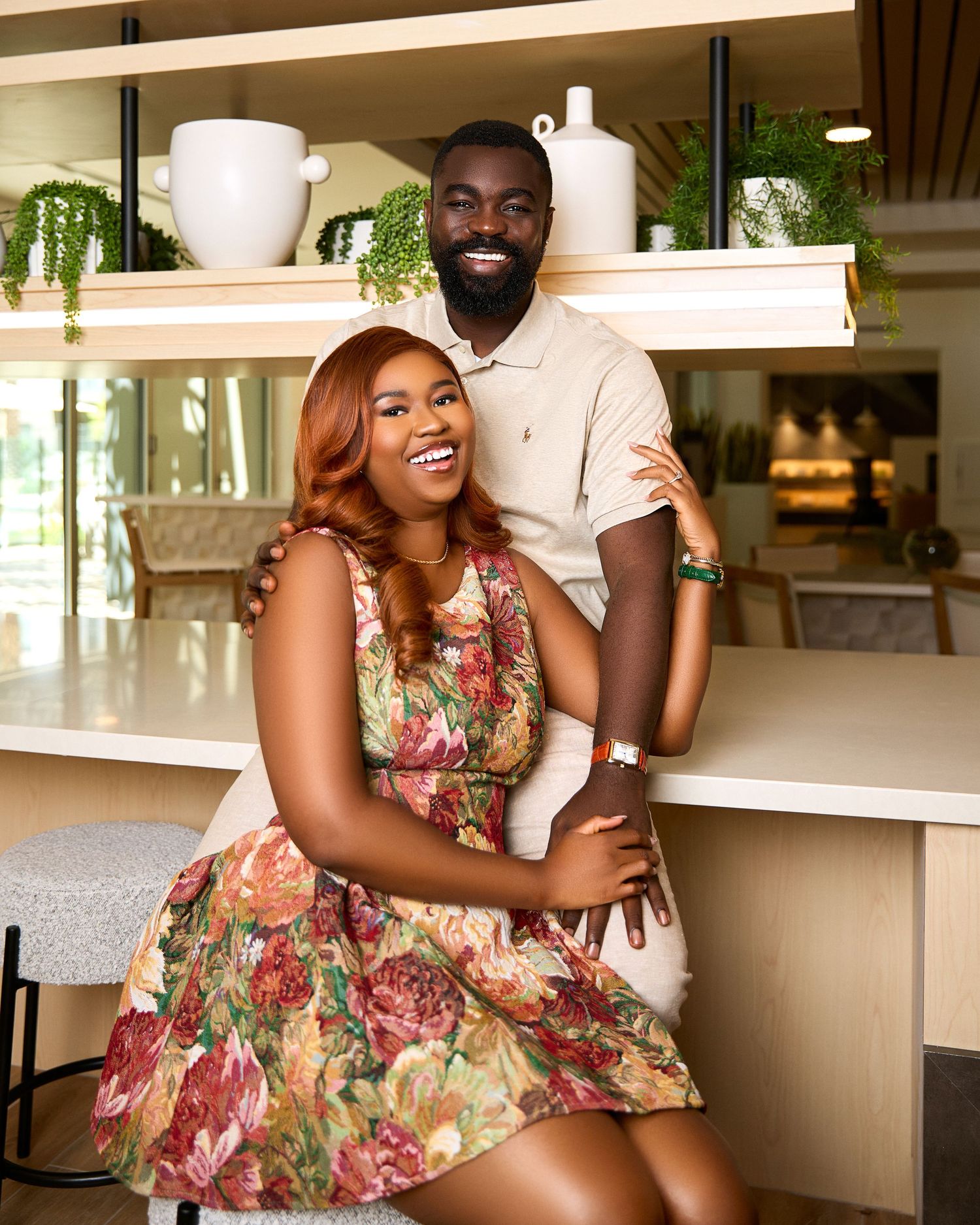 Couple shares joyful moments in casual setting with floral dress.
