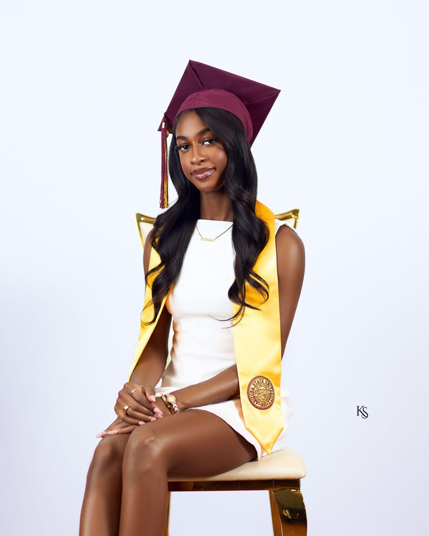 Graduation portrait session showing elegant poses with cap and gown against white studio backdrop.