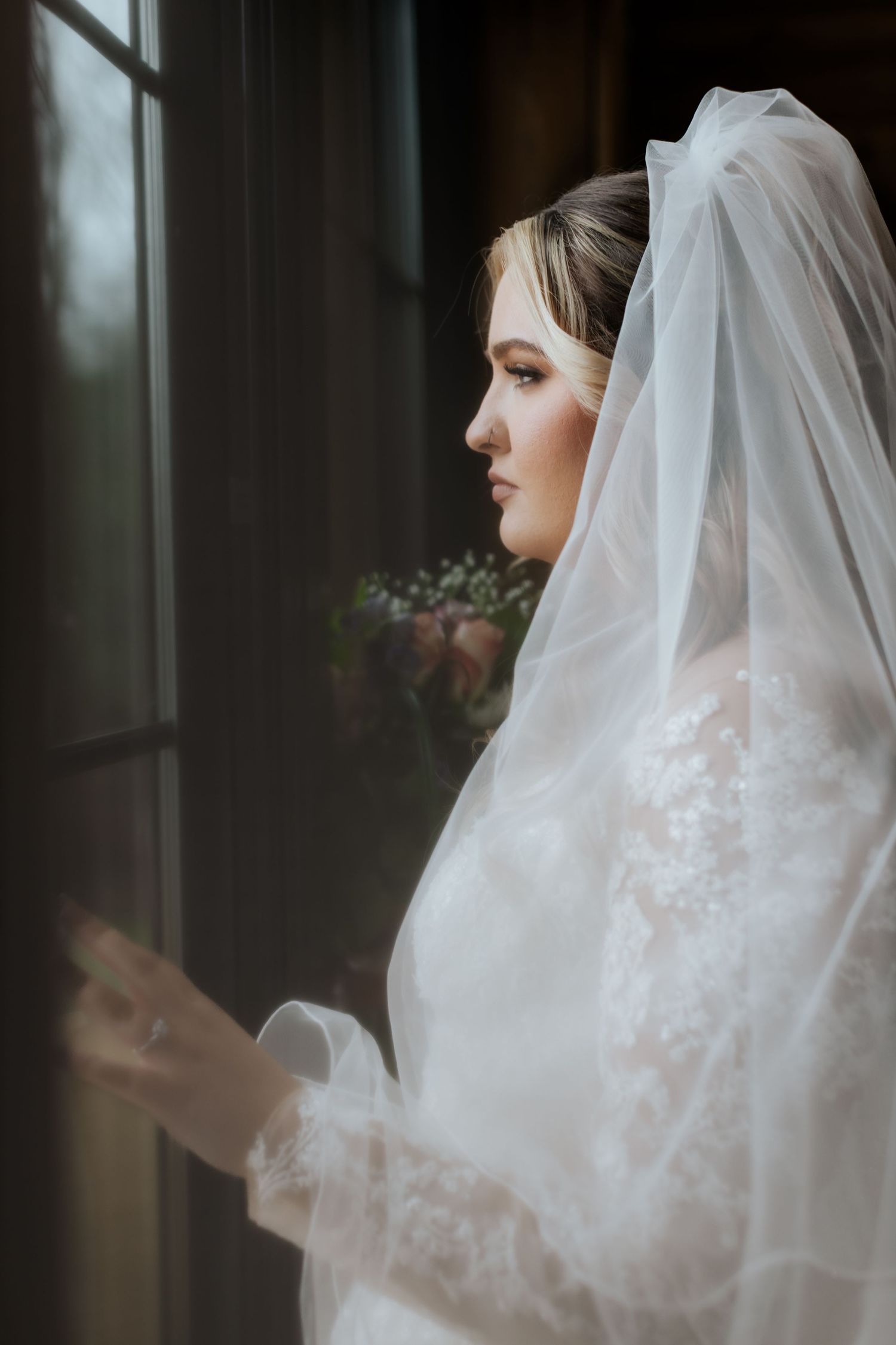 Ethereal bridal veil details with delicate lace embroidery in soft natural light.