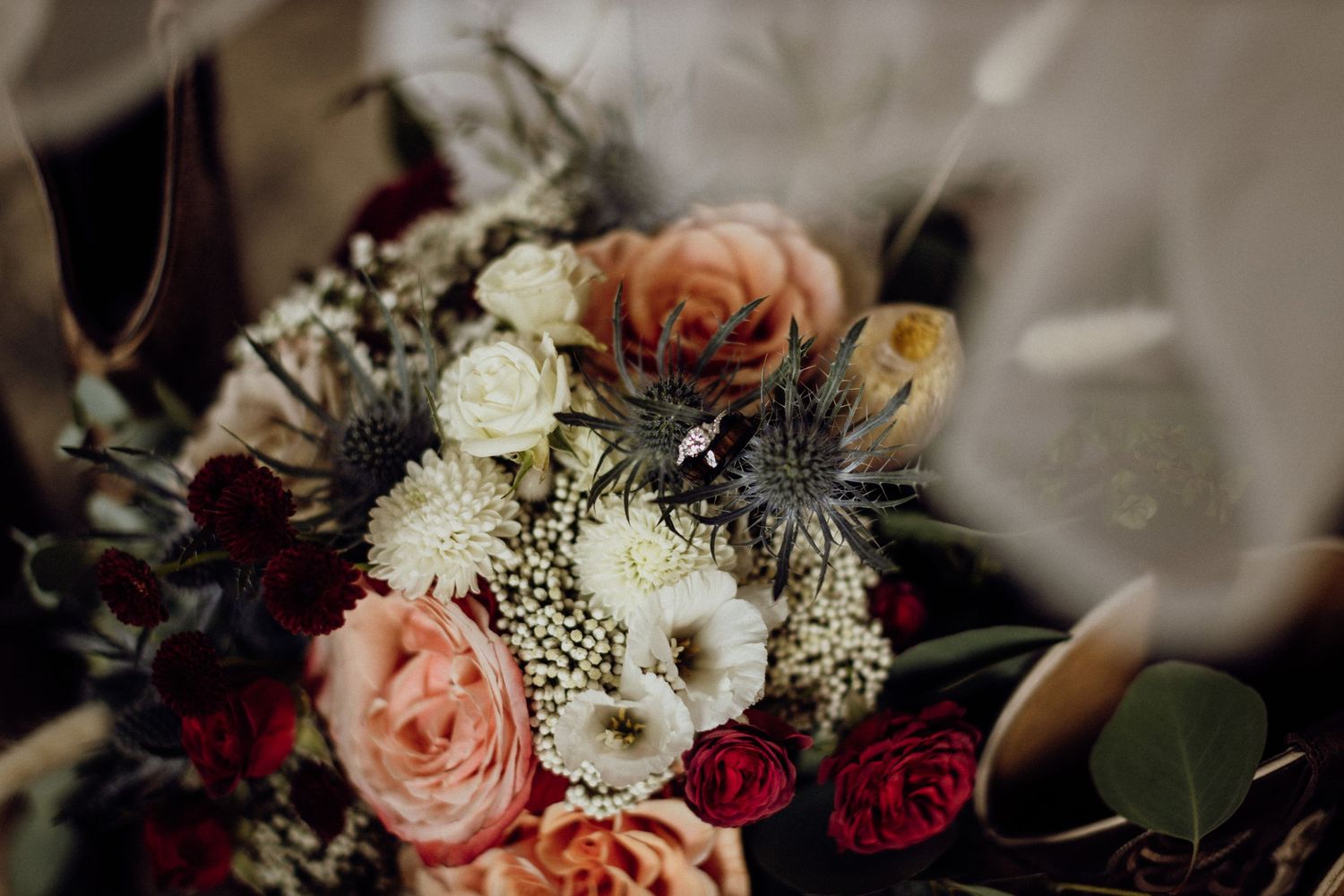 Close-up of delicate pink and white wedding flower arrangements with roses and greenery.