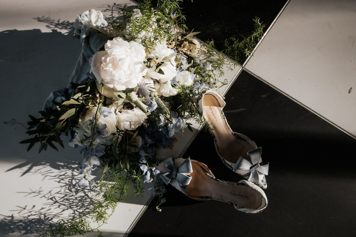 Artistic overhead shot of white wedding florals against dark background.