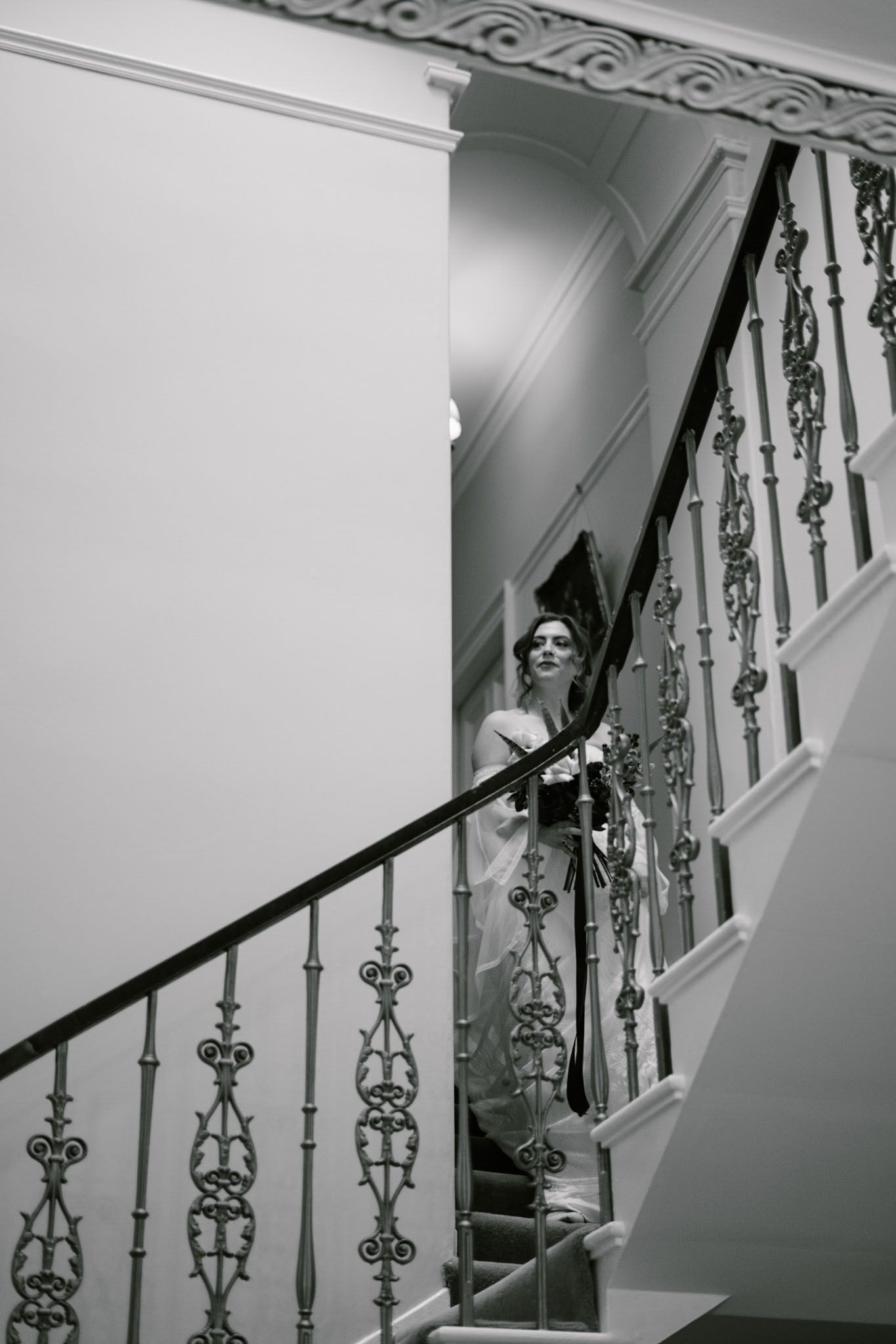 Black and white photos of ornate vintage staircase with decorative iron railings.