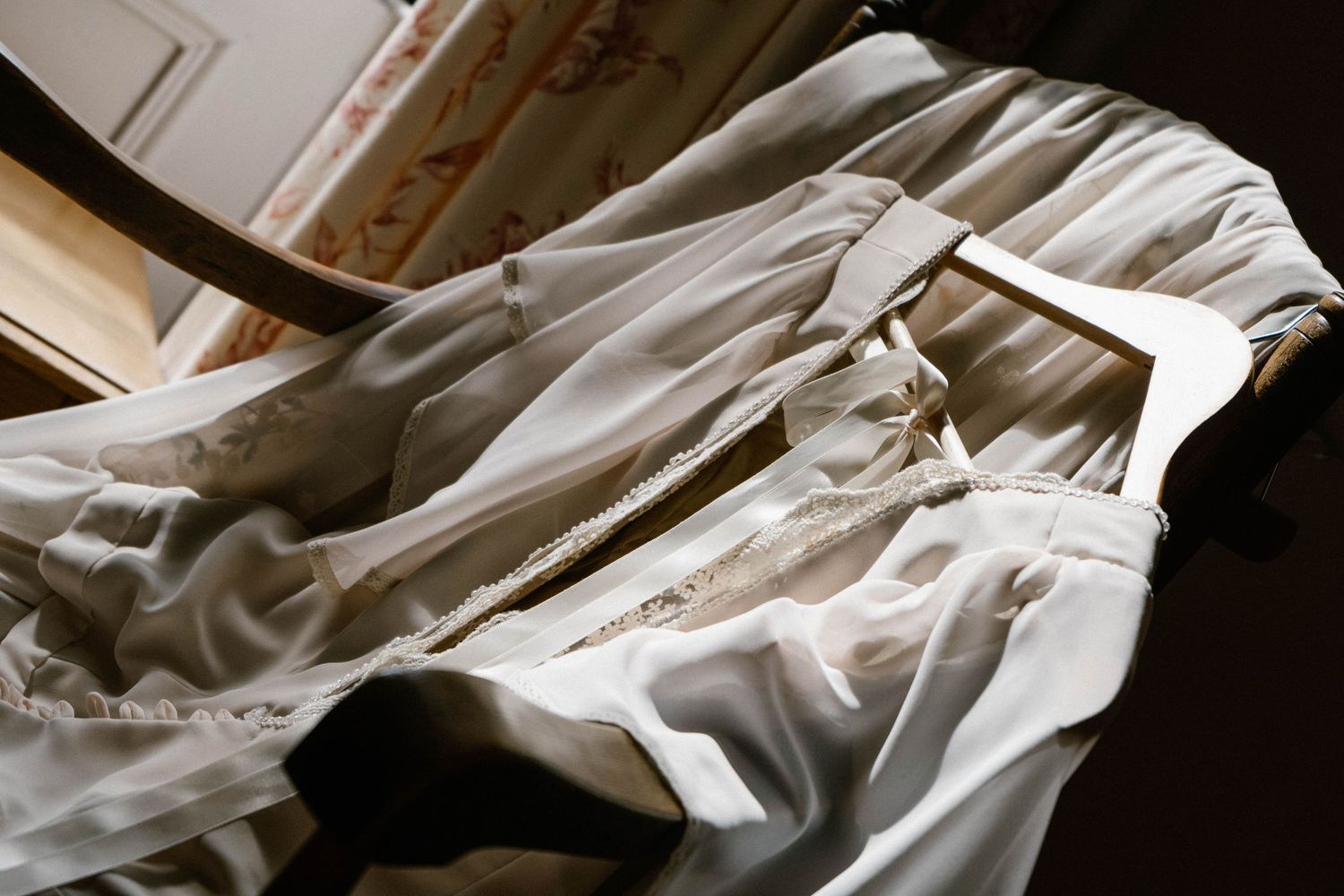 Artistic detail shots of flowing white wedding dress fabric in dramatic lighting.