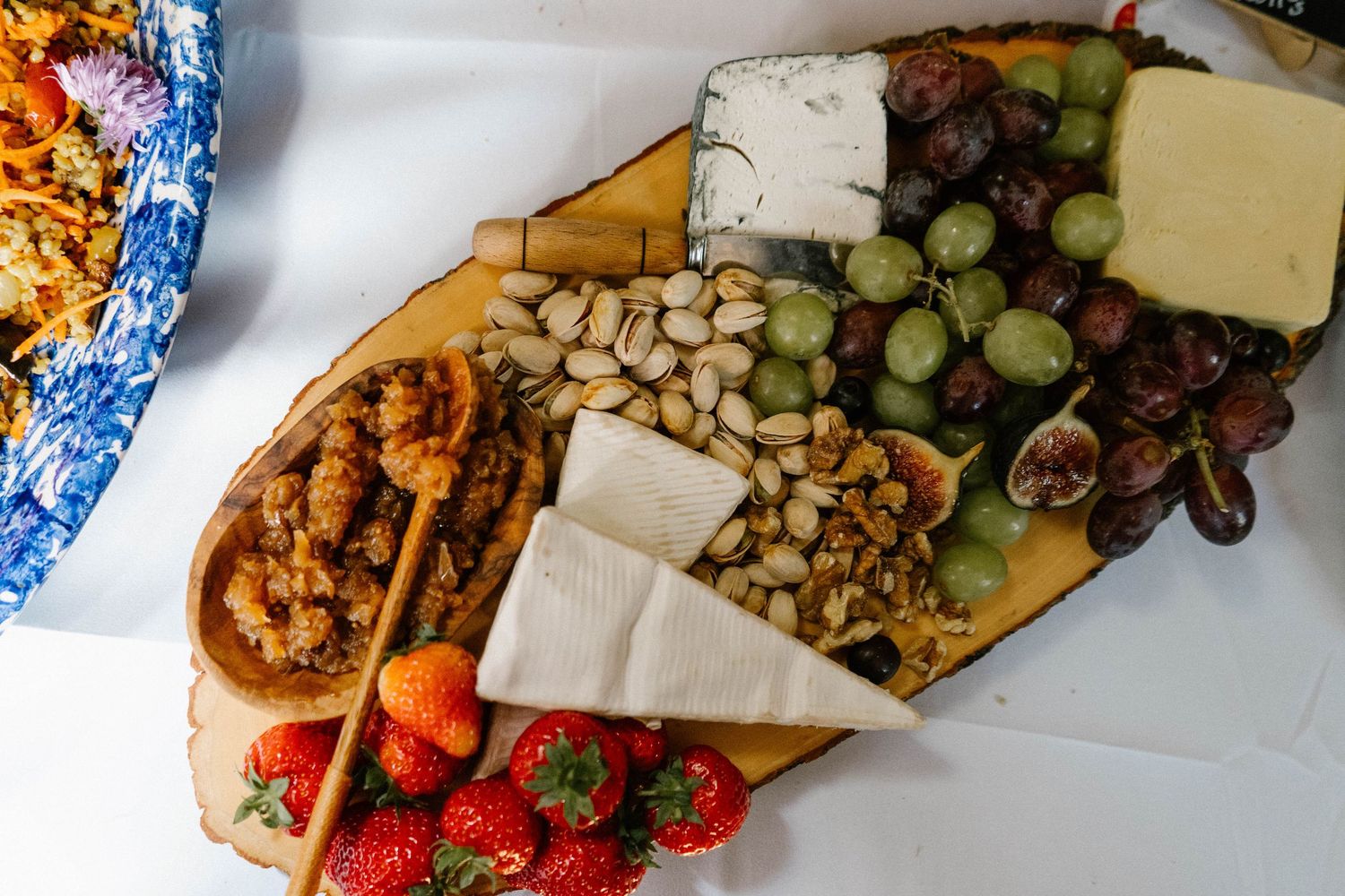 Charcuterie board with assorted fruits, cheeses and meats at a wedding reception.
