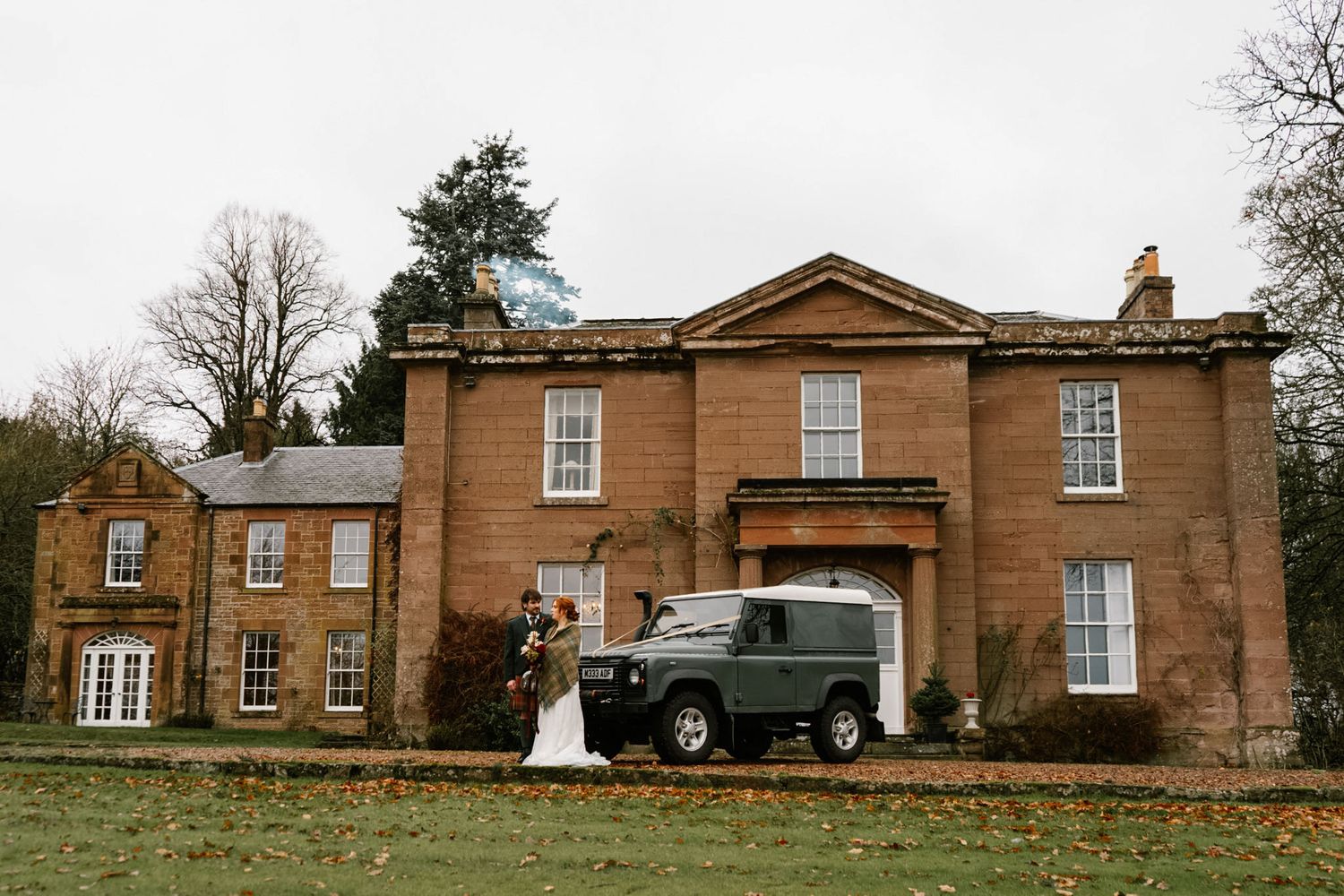 Exterior view of a grand historic sandstone mansion with Georgian architectural features.