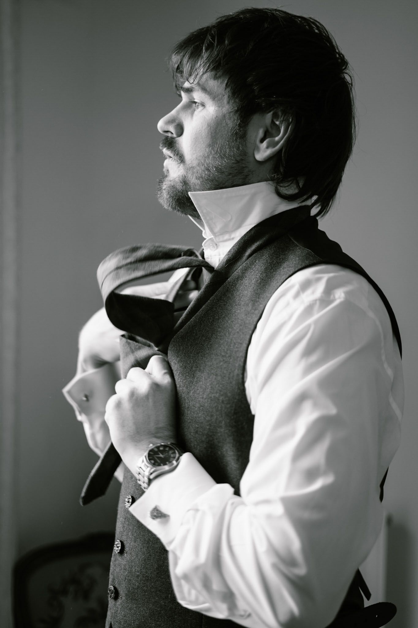 Black and white sequence of someone adjusting a bowtie and formal attire.