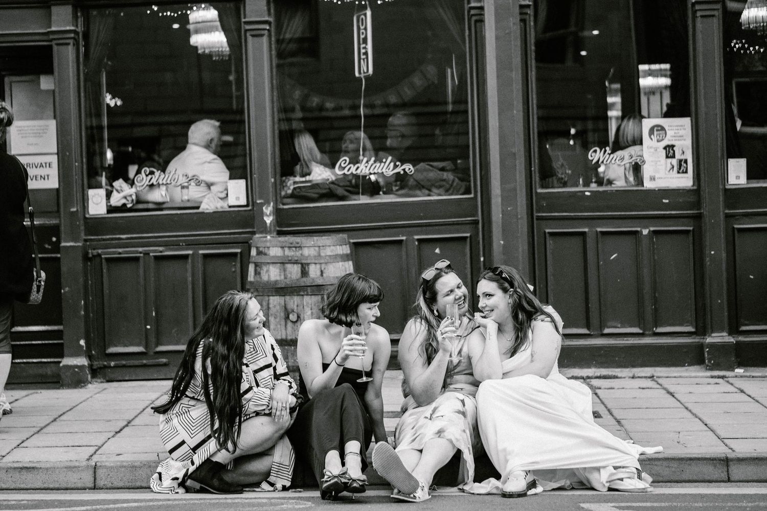 Black and white wedding portraits taken in front of vintage storefronts with ornate details.