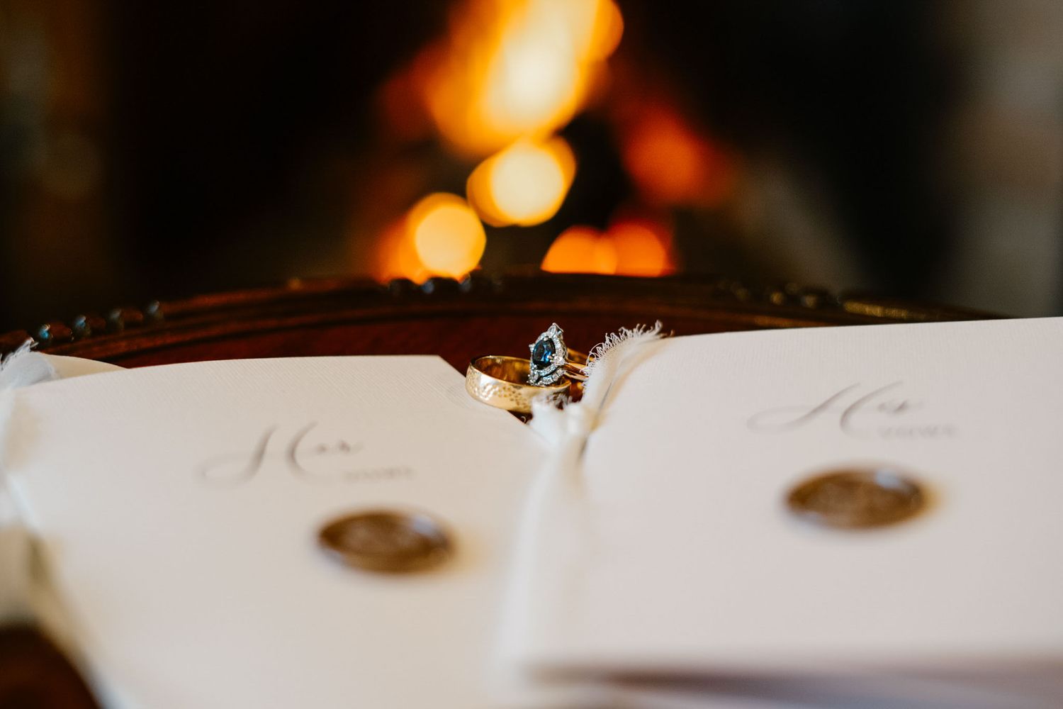 Soft candlelight illuminates wedding reception table settings with a warm golden glow.
