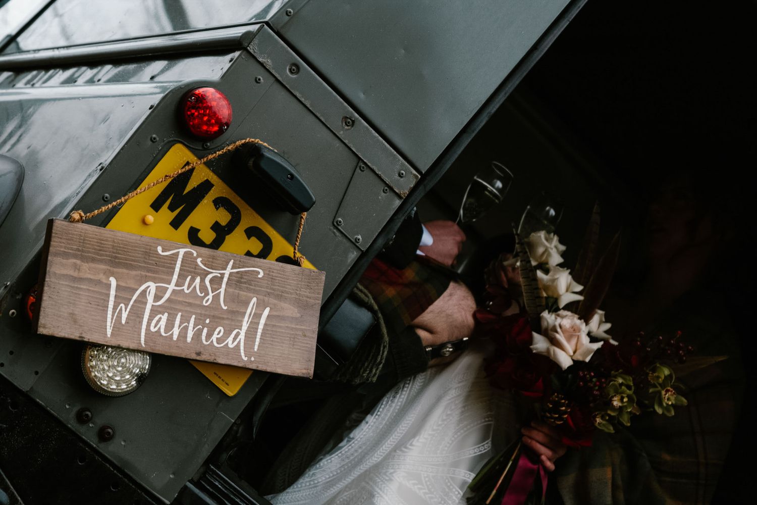 Wedding decor details including red ornaments, signage, and rustic elements in a dark moody setting.