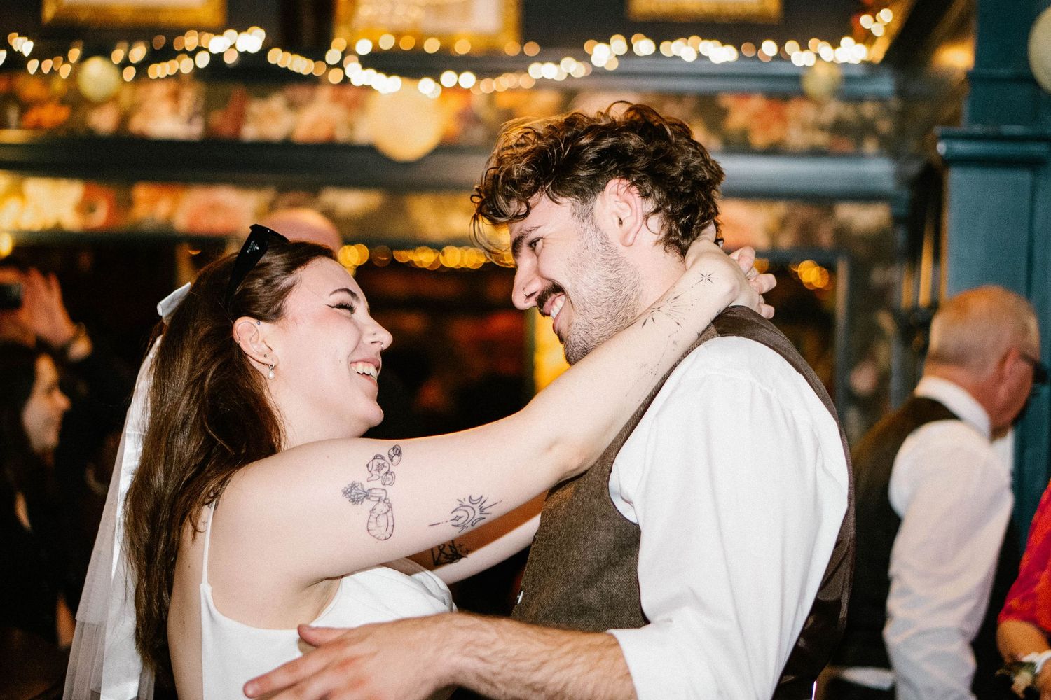 Wedding reception dance floor with warm lighting and guests celebrating.