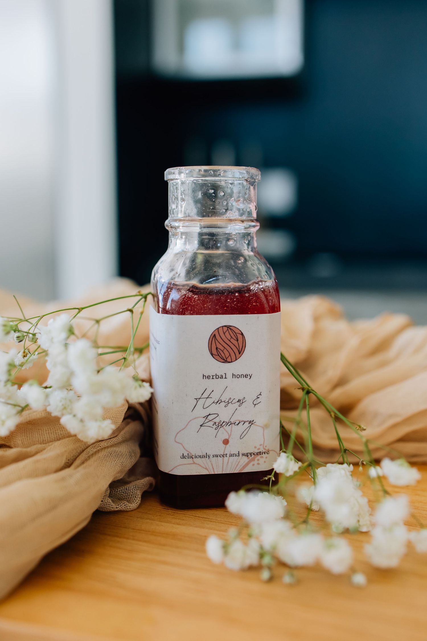Branding image for an herbal honey company featuring their product surrounded by babies breath