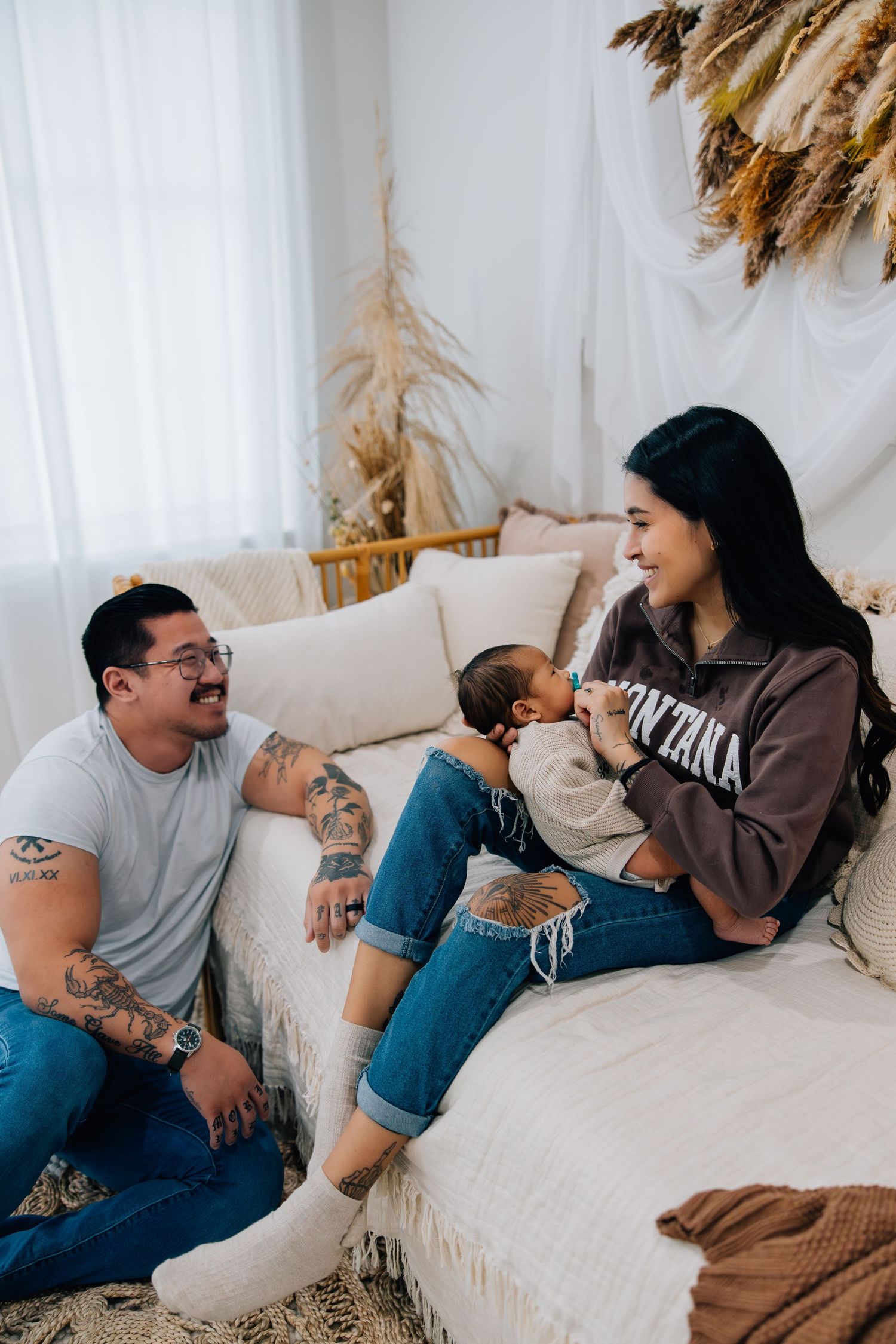 Portrait photography of a small family featuring parents holding their new infant