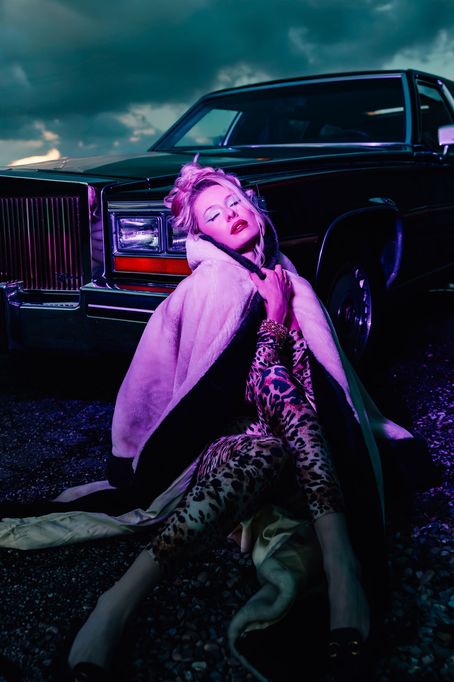 Editorial-style image featuring woman in 80s attire sitting in front of a vintage limo